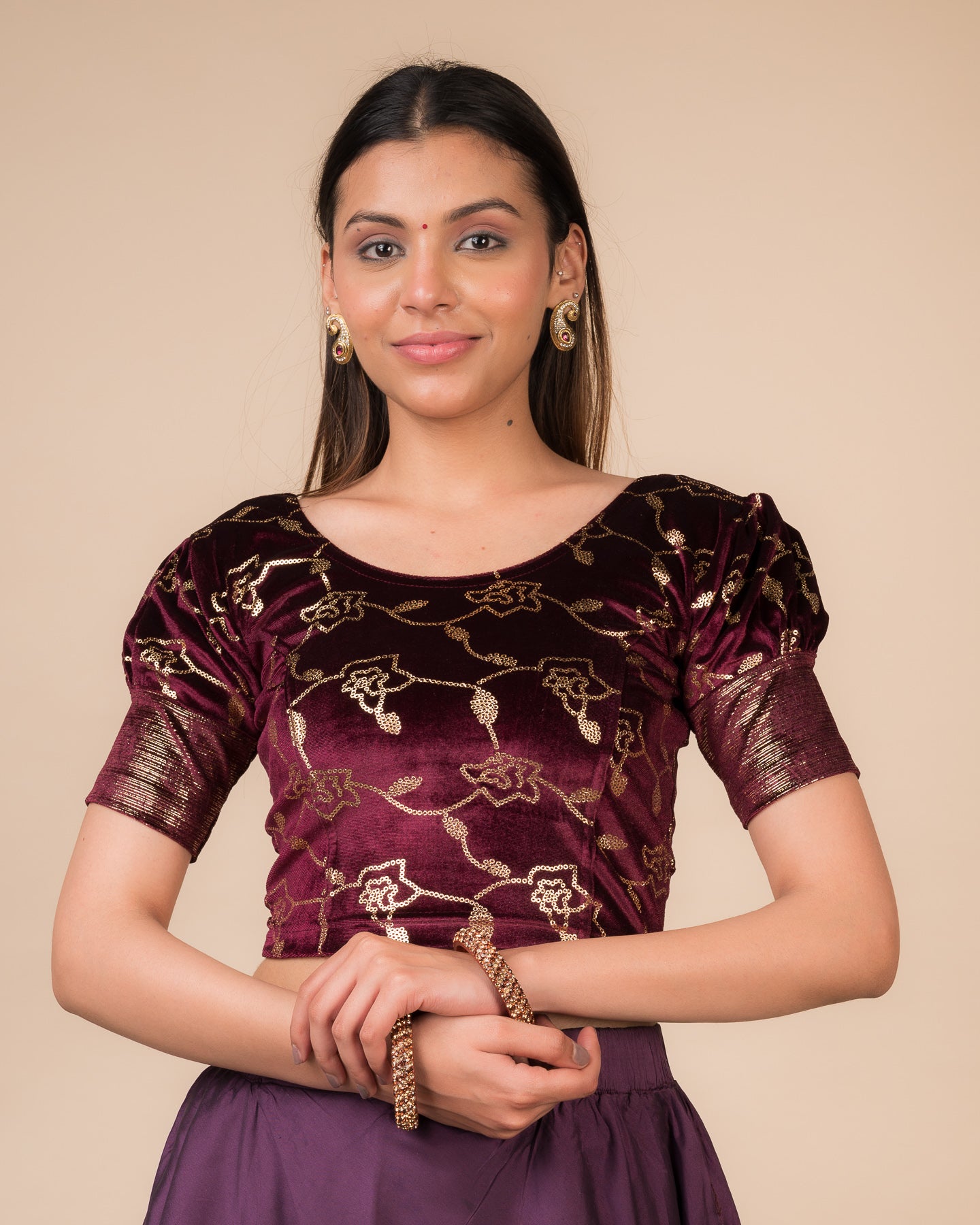 Model wearing a velvet blouse with metallic sequin foil, elbow puff sleeves, and round neckline