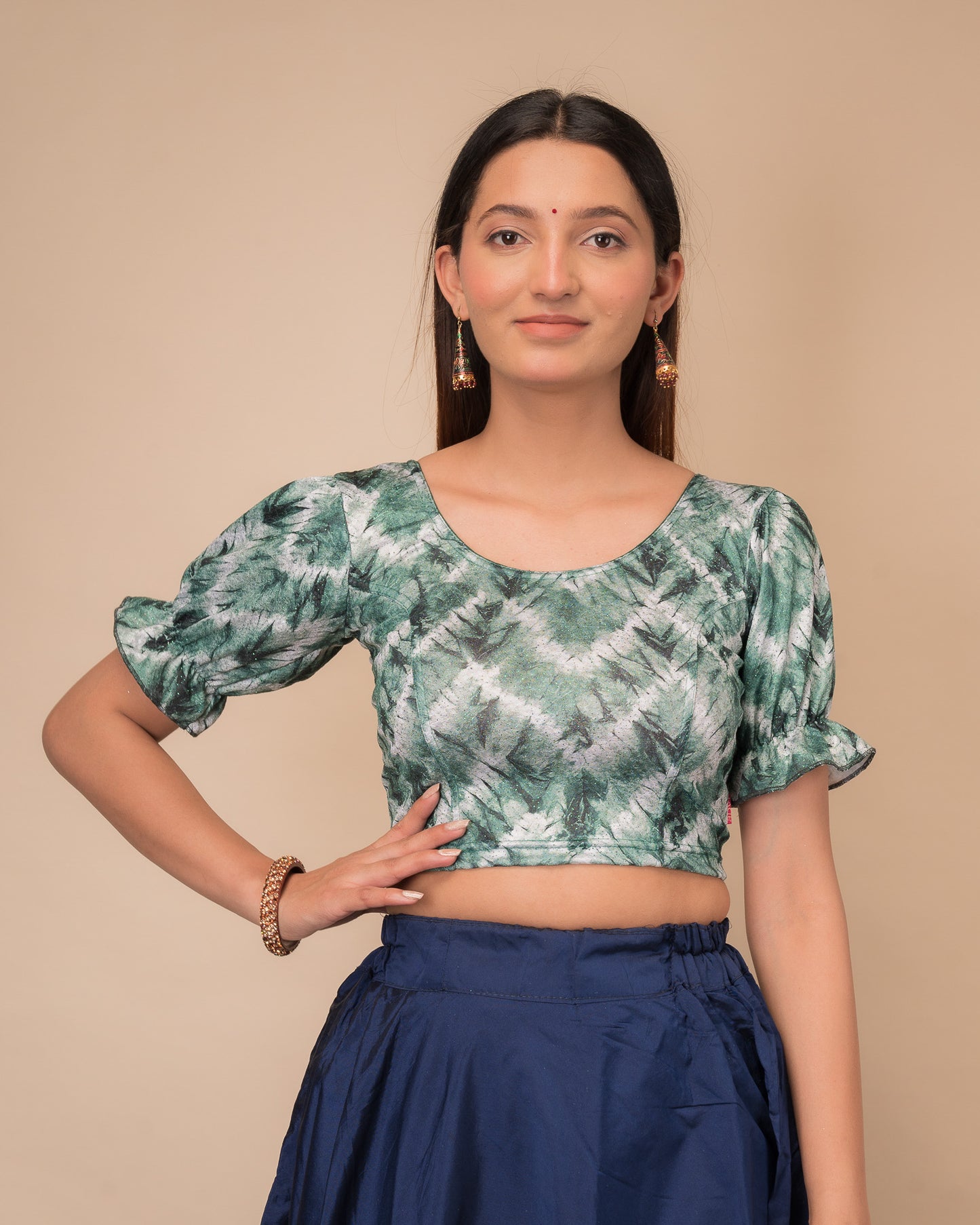 Model wearing a stretchable shibori blouse with glitter, sleek pleated elbow sleeves, and round neckline