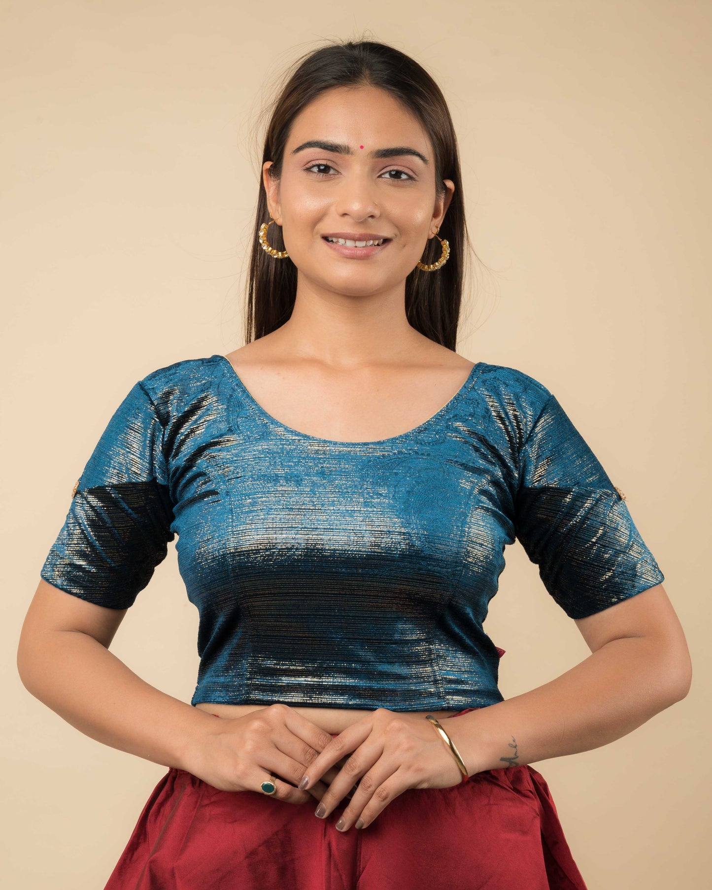 Model wearing a velvet blouse with gold buti and stripes, elbow sleeves, and round neckline