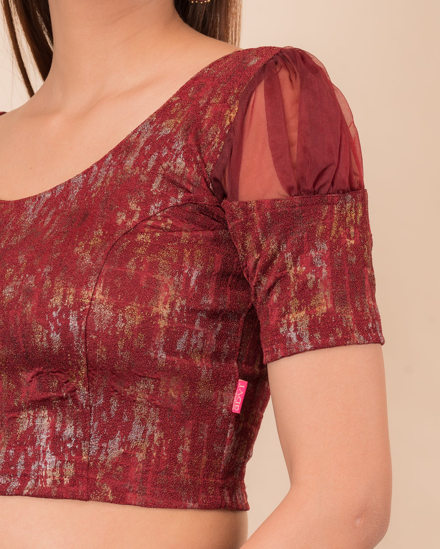 Close-up of the multi-foil textured knit and sheer sleeve detail