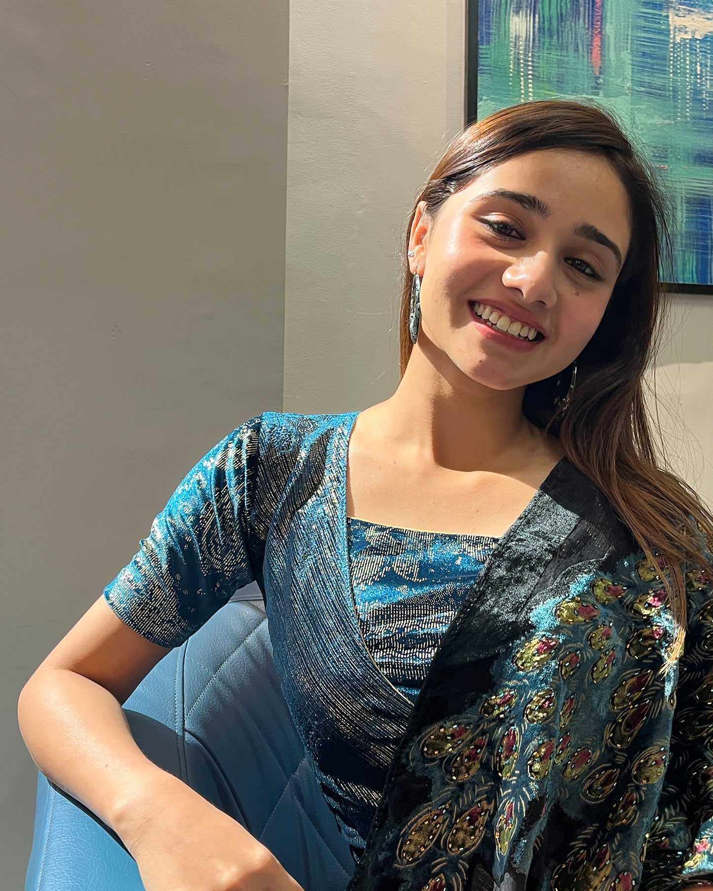Model pairing the teal blue-colored velvet embellished stretchable choli-style blouse with a traditional saree, demonstrating a complete festive look.