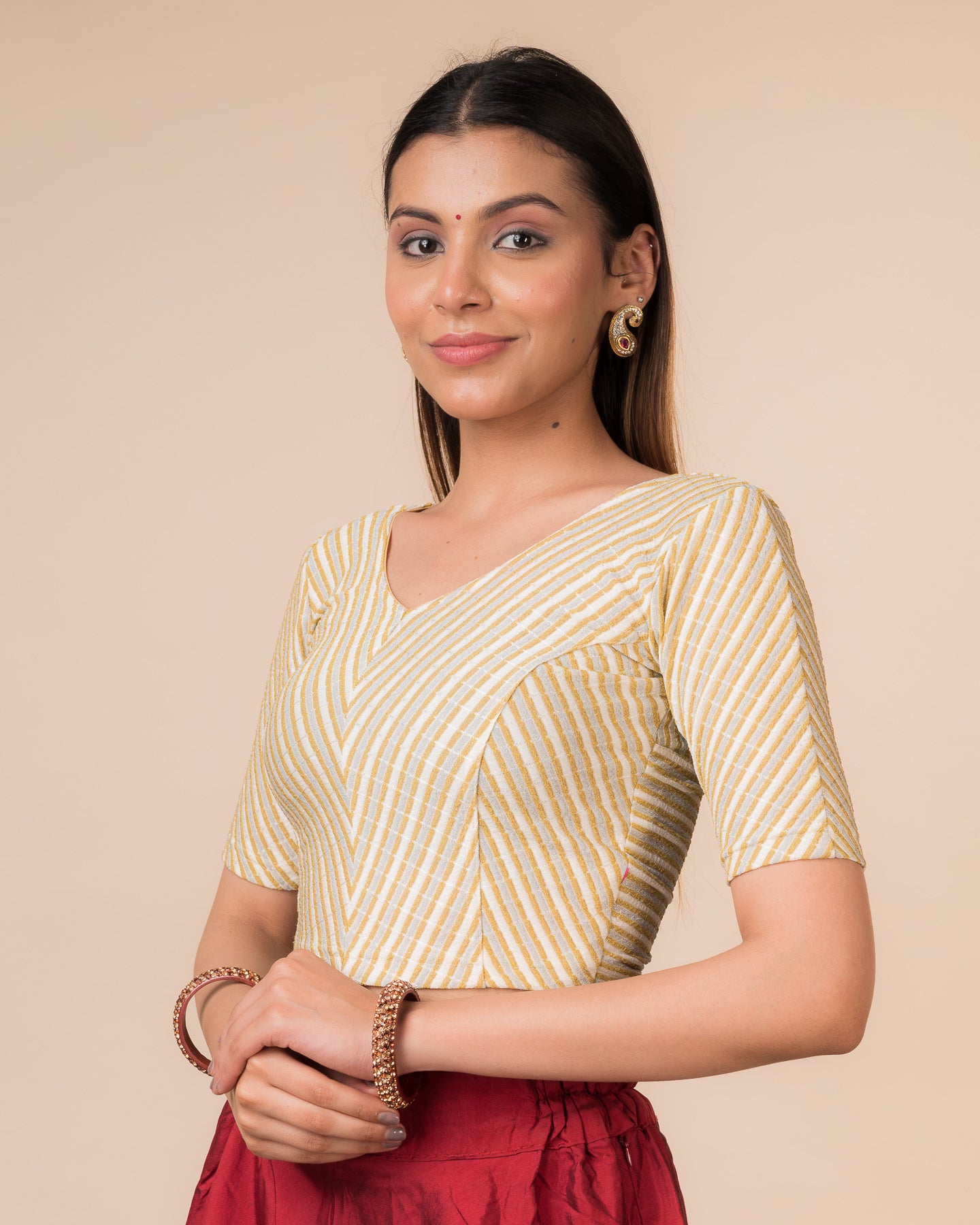 Side profile of the cream gold zari stretchable blouse highlighting the fit and sleeve length.