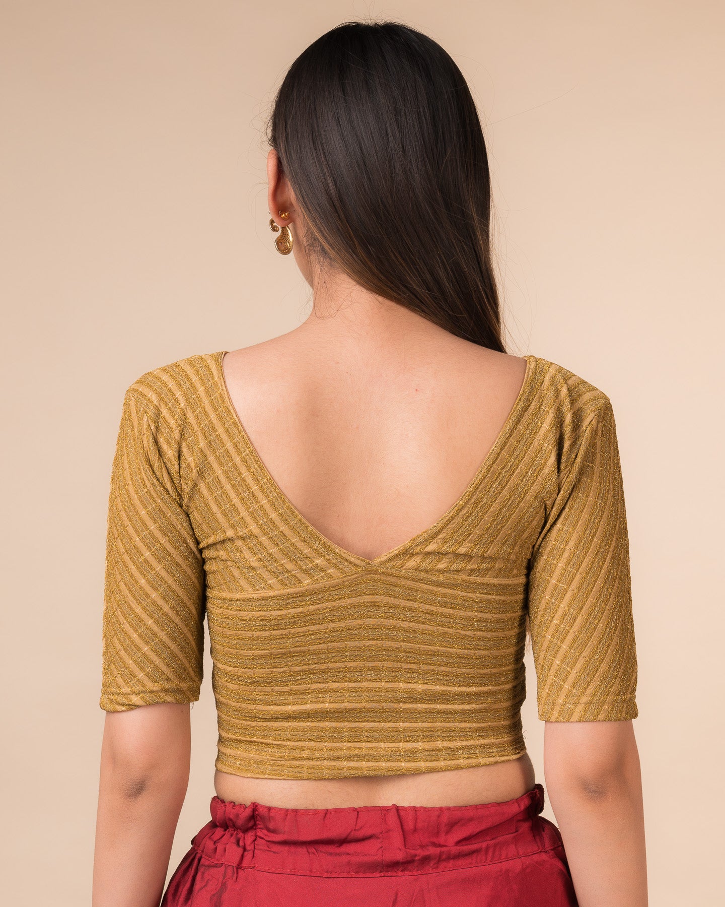 Rear view of the dark gold zari stretchable blouse showcasing the deep V-back design.