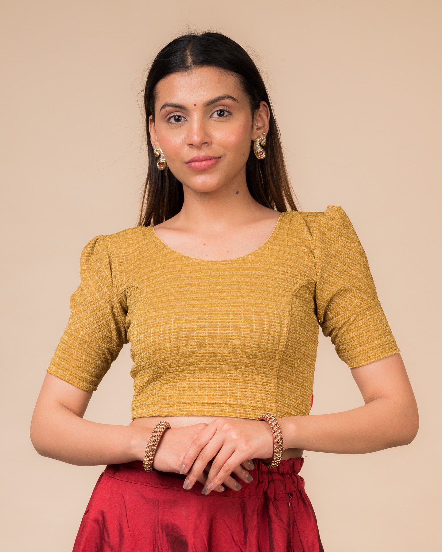 Model wearing a zari double-stripe stretchable readymade blouse with puff elbow sleeves and round neckline.