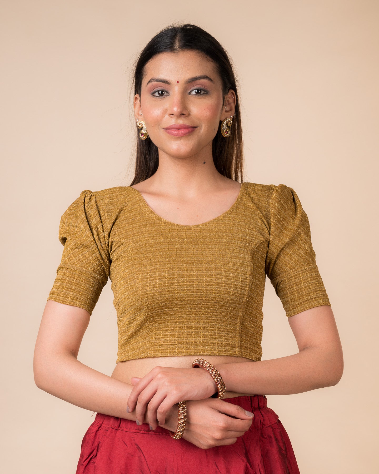 Model wearing a zari stripe stretchable readymade blouse with puff elbow sleeves and round neckline.