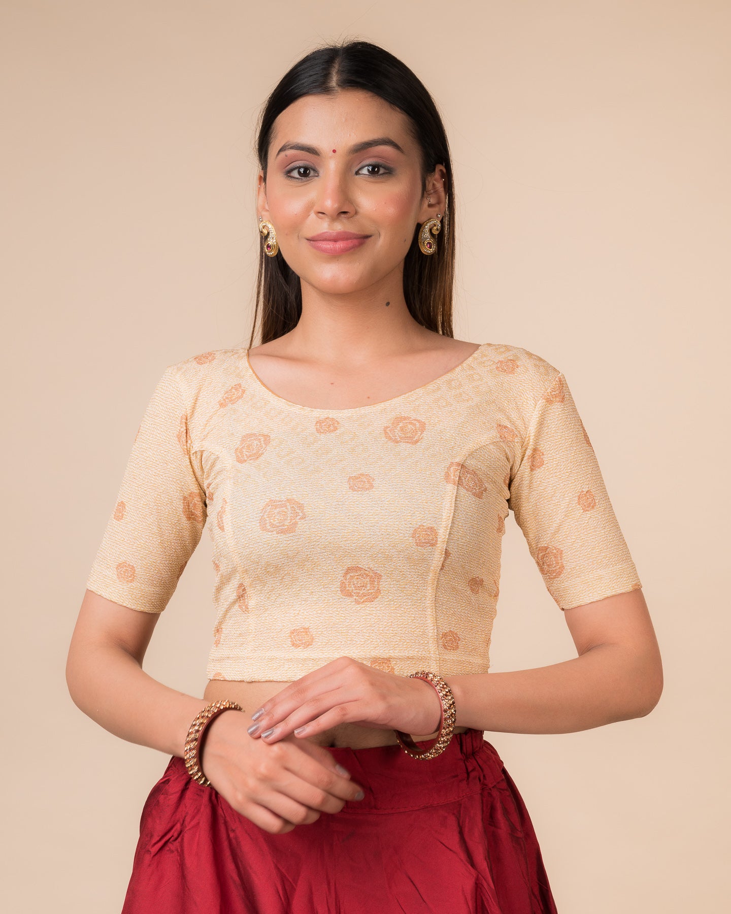 Model wearing a metallic zigzag stretchable readymade blouse with elbow sleeves and round neckline.