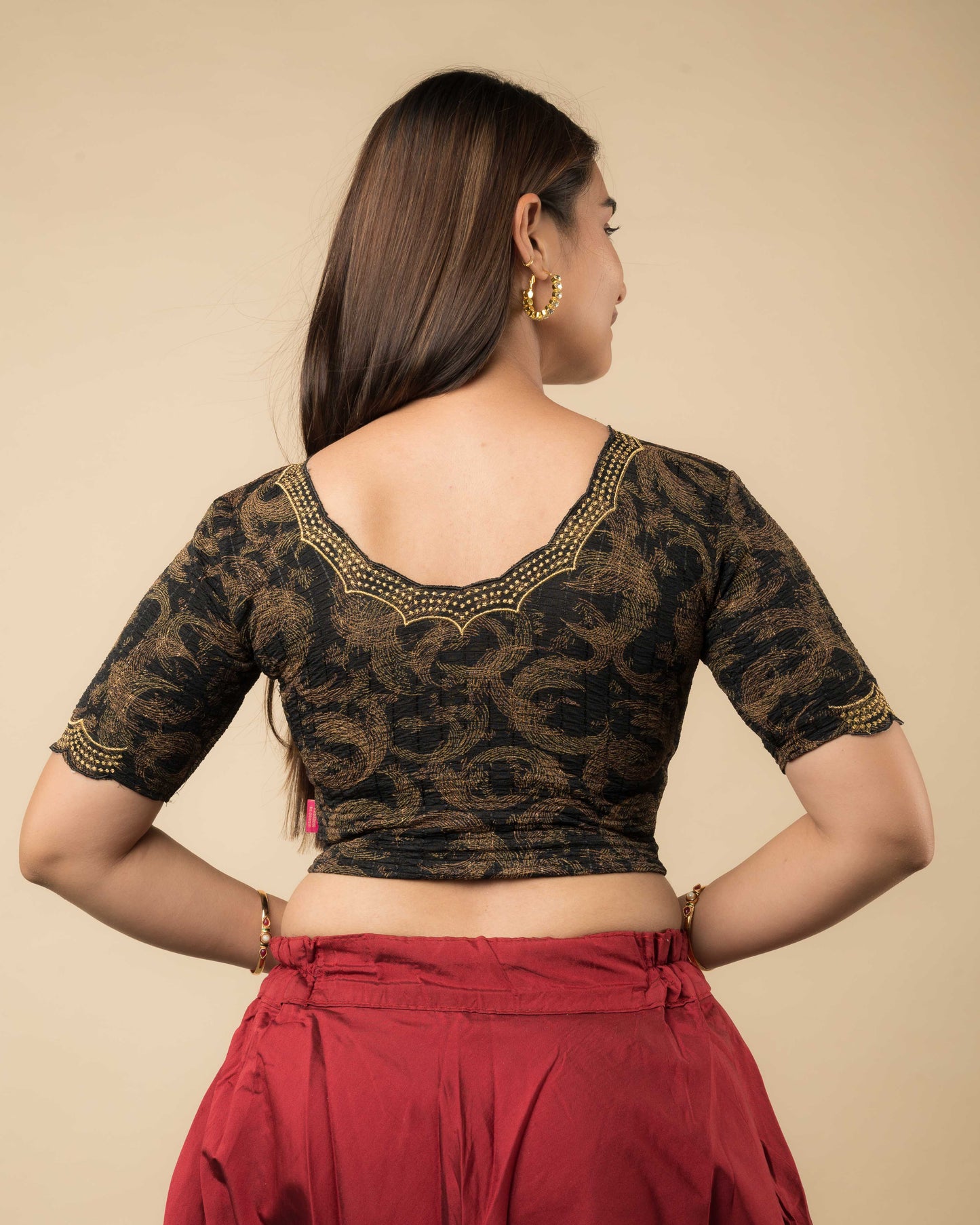 Rear view of the black-colored stretchable blouse showcasing the back design and zari embroidery.