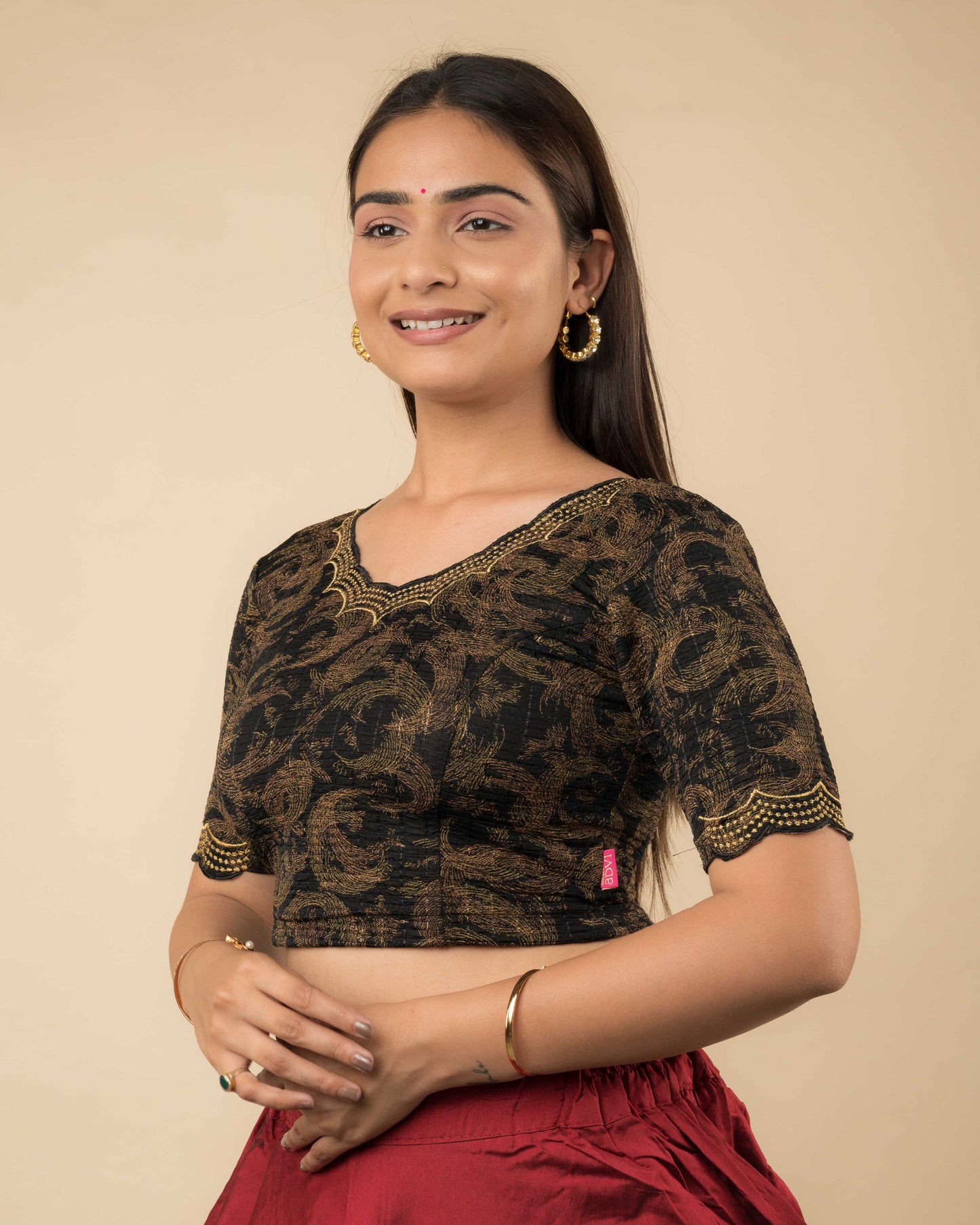 Side profile of the black-colored stretchable blouse highlighting the fit, sleeve length, and zari embroidery.
