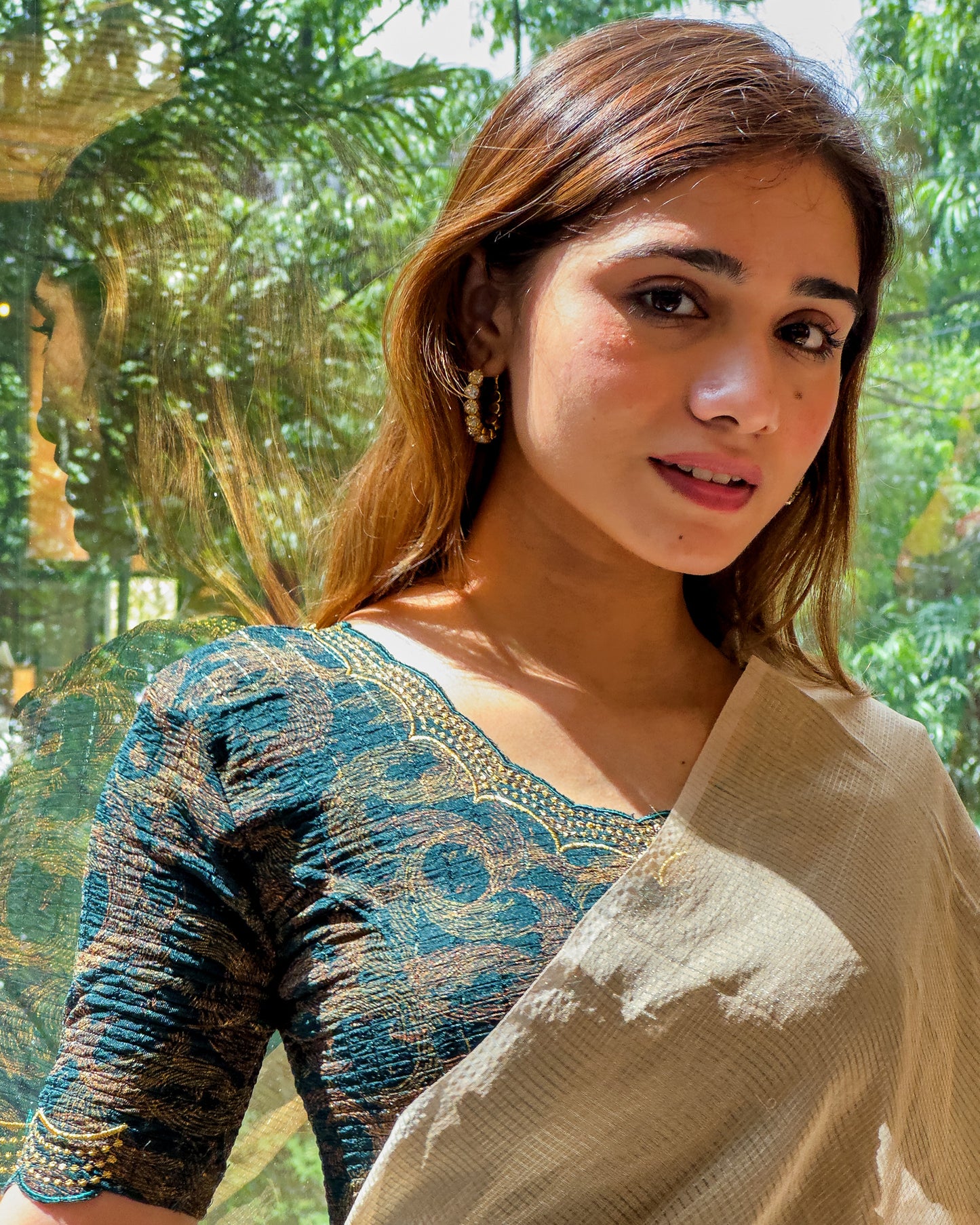 Model pairing the bottle green-colored stretchable blouse with a traditional saree, demonstrating a complete ethnic look.