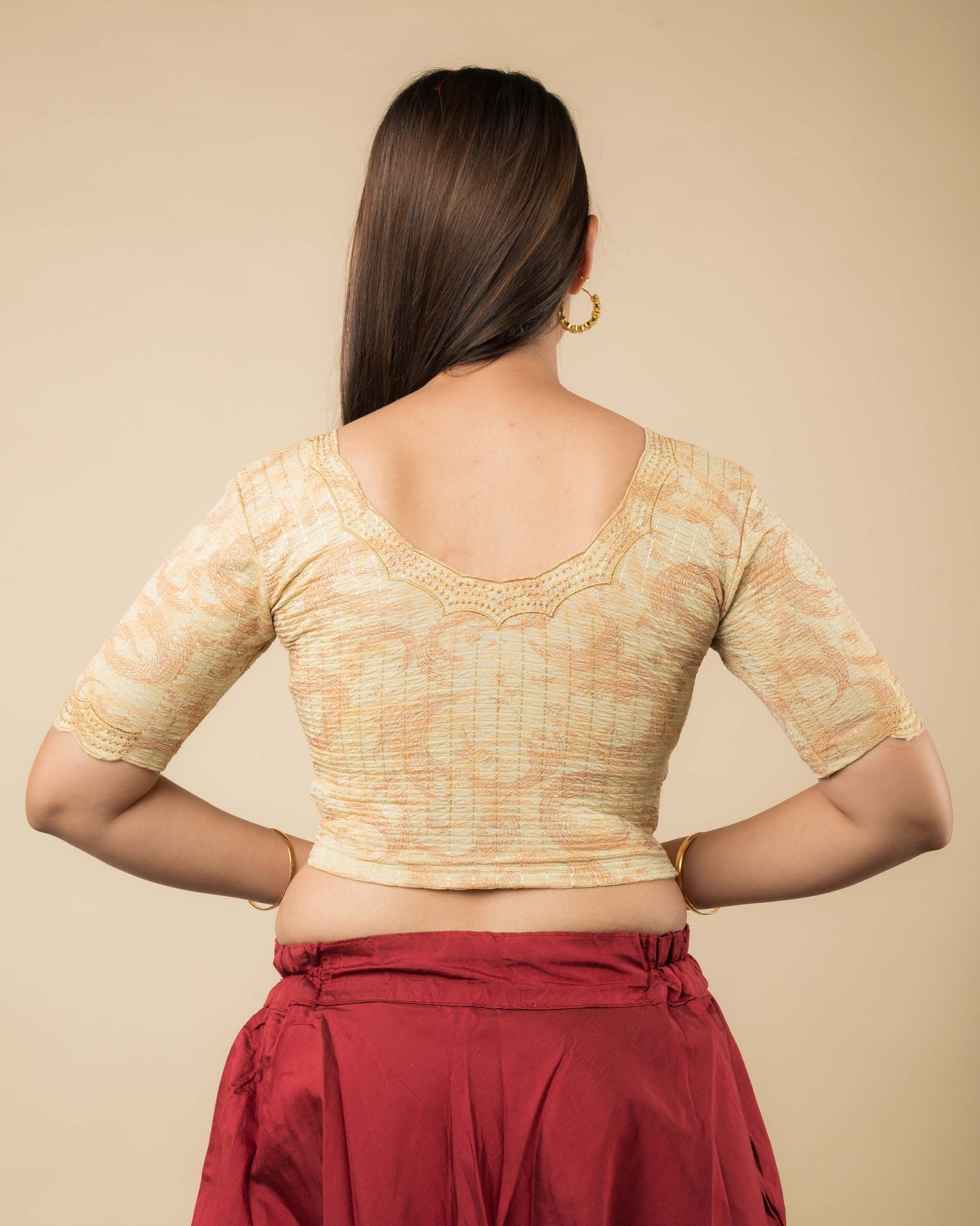 Rear view of the gold-colored stretchable blouse showcasing the back design and zari embroidery.