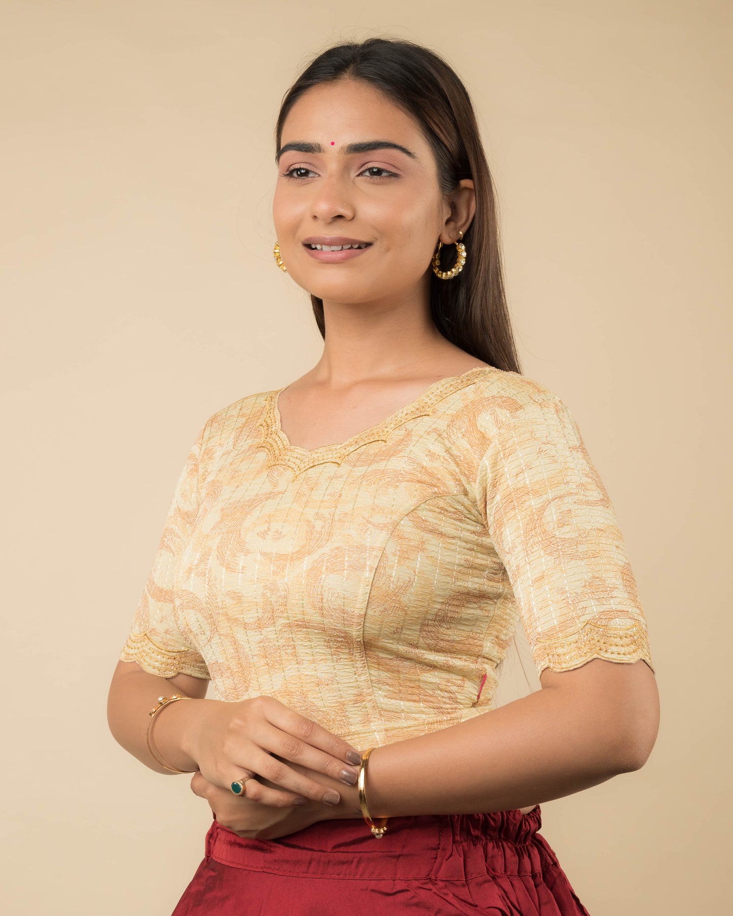 Side profile of the gold-colored stretchable blouse highlighting the fit, sleeve length, and zari embroidery