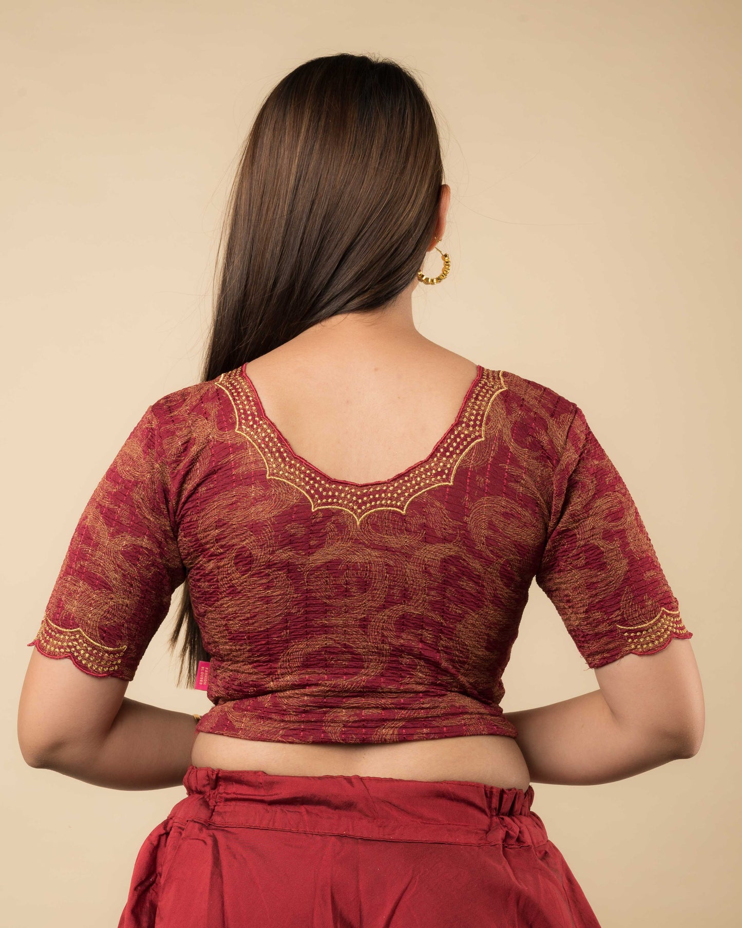 Rear view of the maroon-colored stretchable blouse showcasing the back design and zari embroidery.