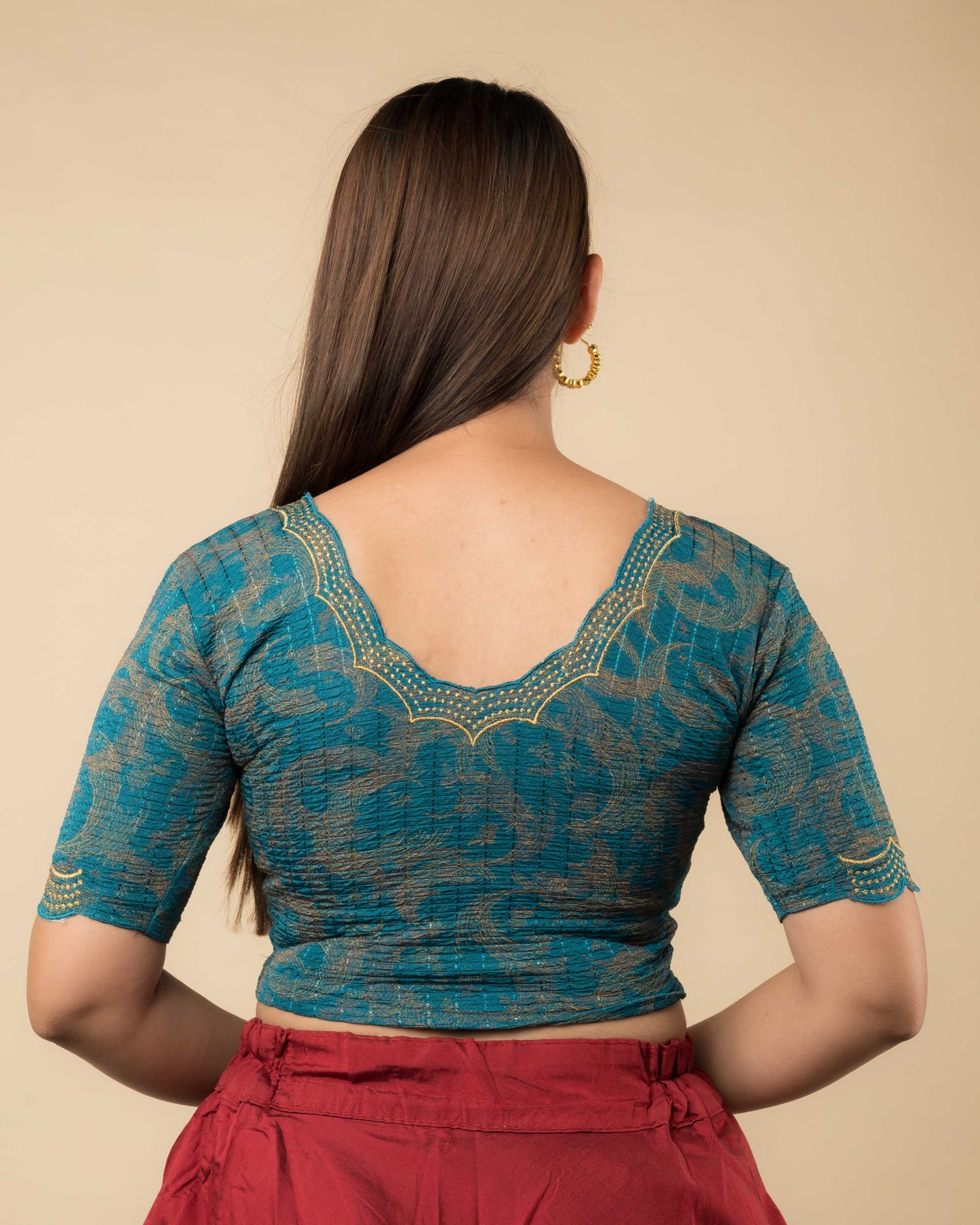 Rear view of the rama green-colored stretchable blouse showcasing the back design and zari embroidery.