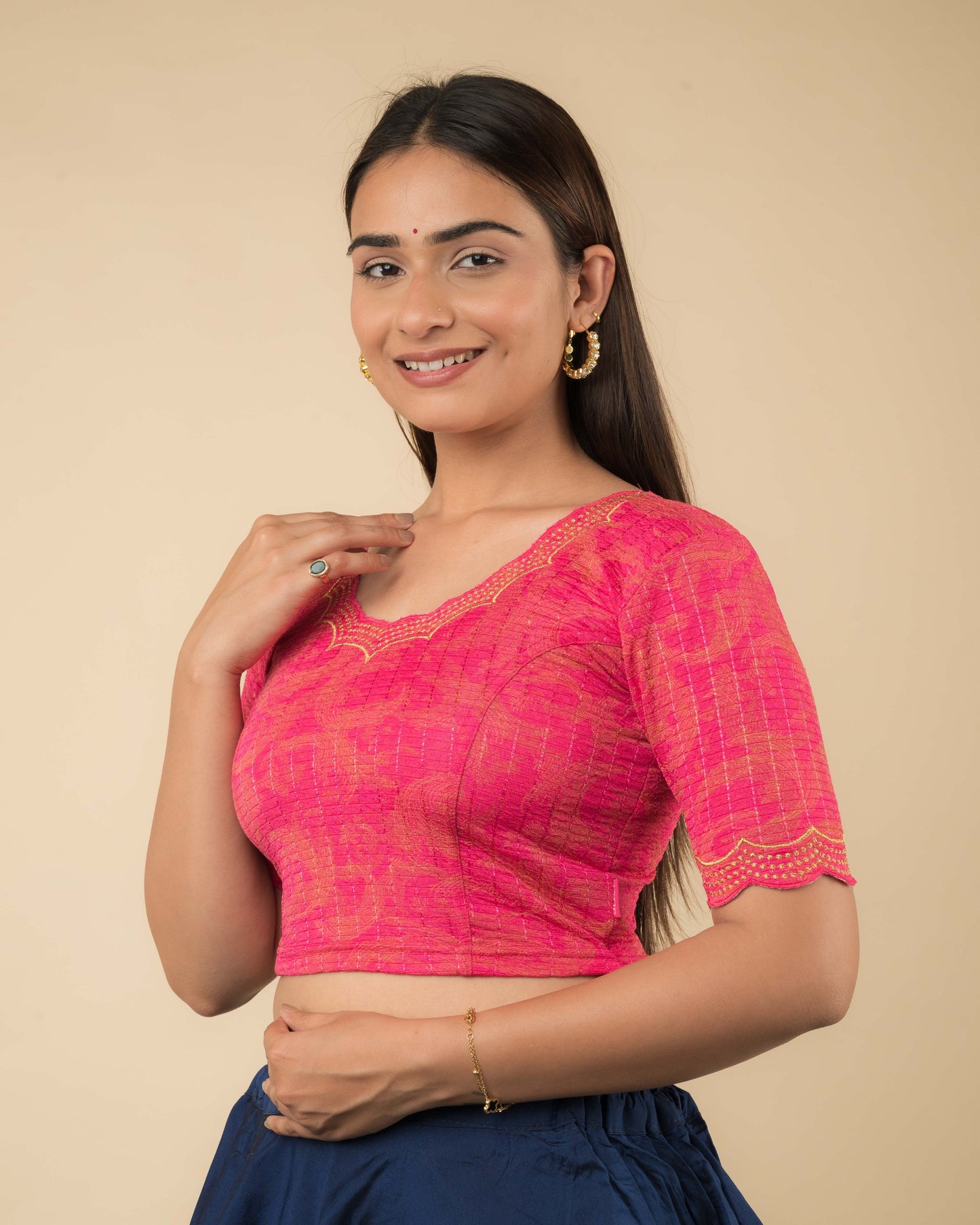 Side profile of the rani-colored stretchable blouse highlighting the fit, sleeve length, and zari embroidery.