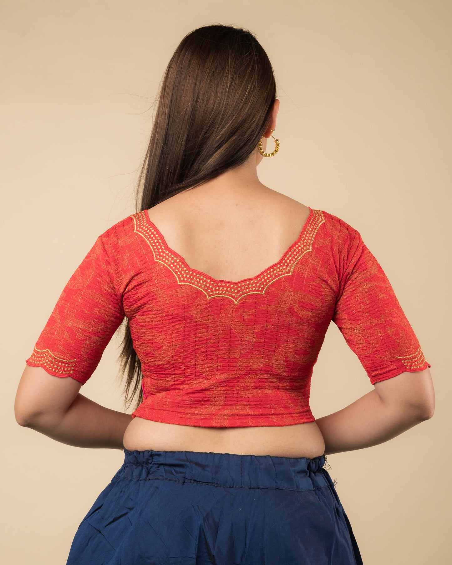 Rear view of the red-colored stretchable blouse showcasing the back design and zari embroidery.