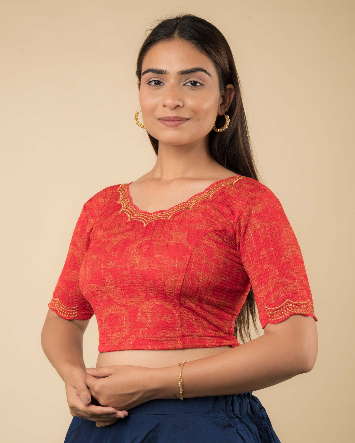 Side profile of the red-colored stretchable blouse highlighting the fit, sleeve length, and zari embroidery.