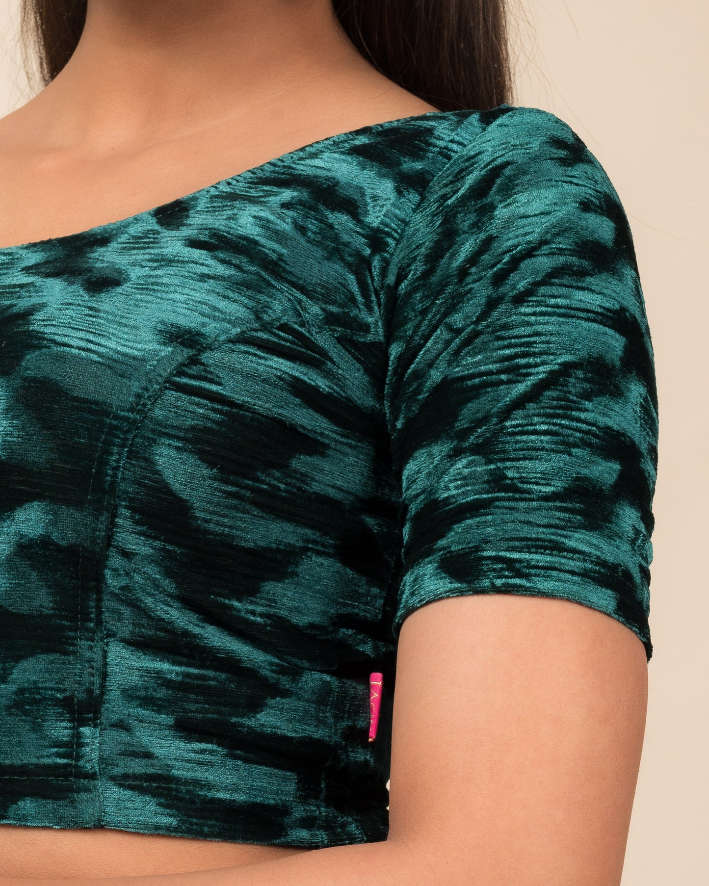 Close-up of the velvet fabric detailing the zari embroidery and stretchability of the readymade blouse.