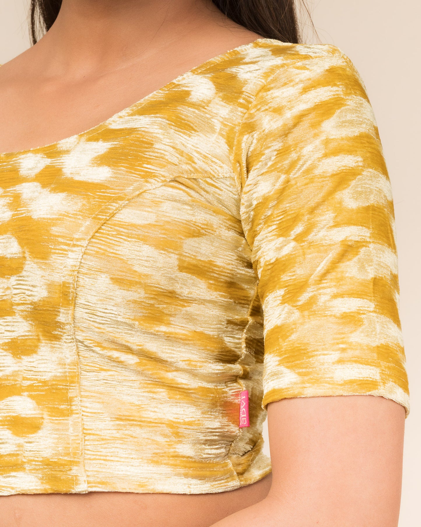 Close-up of the velvet fabric detailing the zari embroidery and stretchability of the readymade blouse.