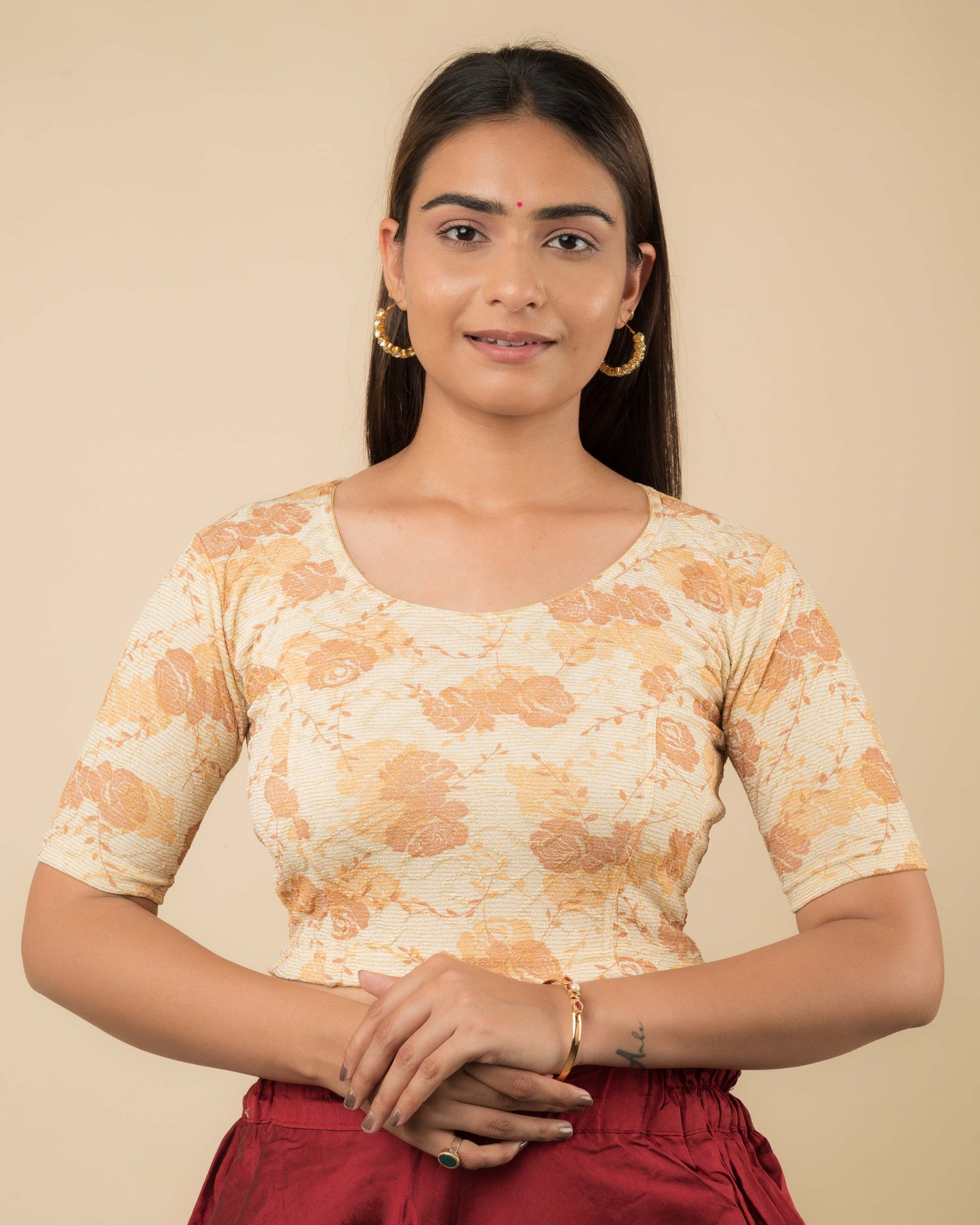 Model wearing a jacquard stretchable readymade blouse with elbow sleeves and round neckline.