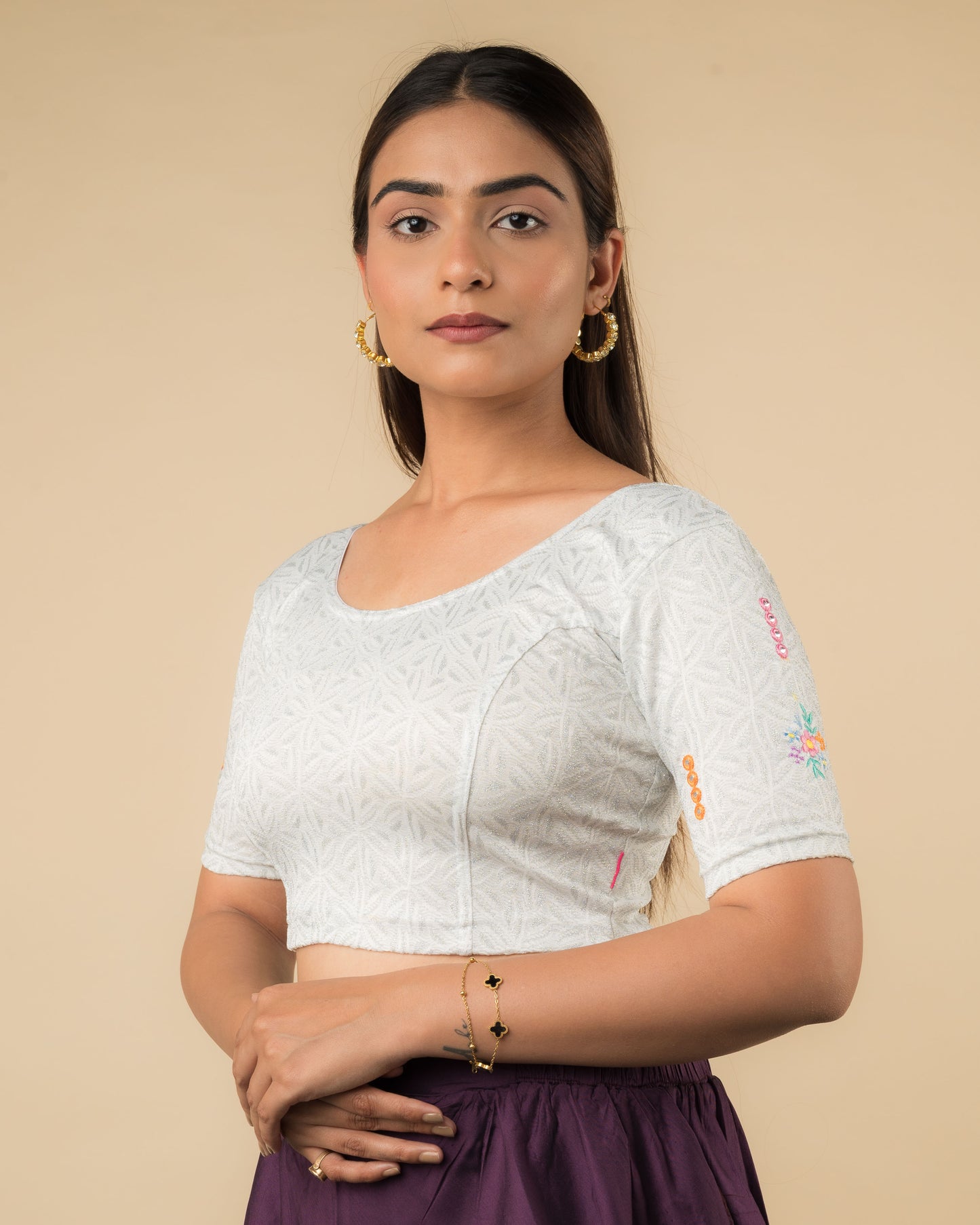 Side profile of the mirror embellished knitted stretchable blouse highlighting the fit and sleeve length.