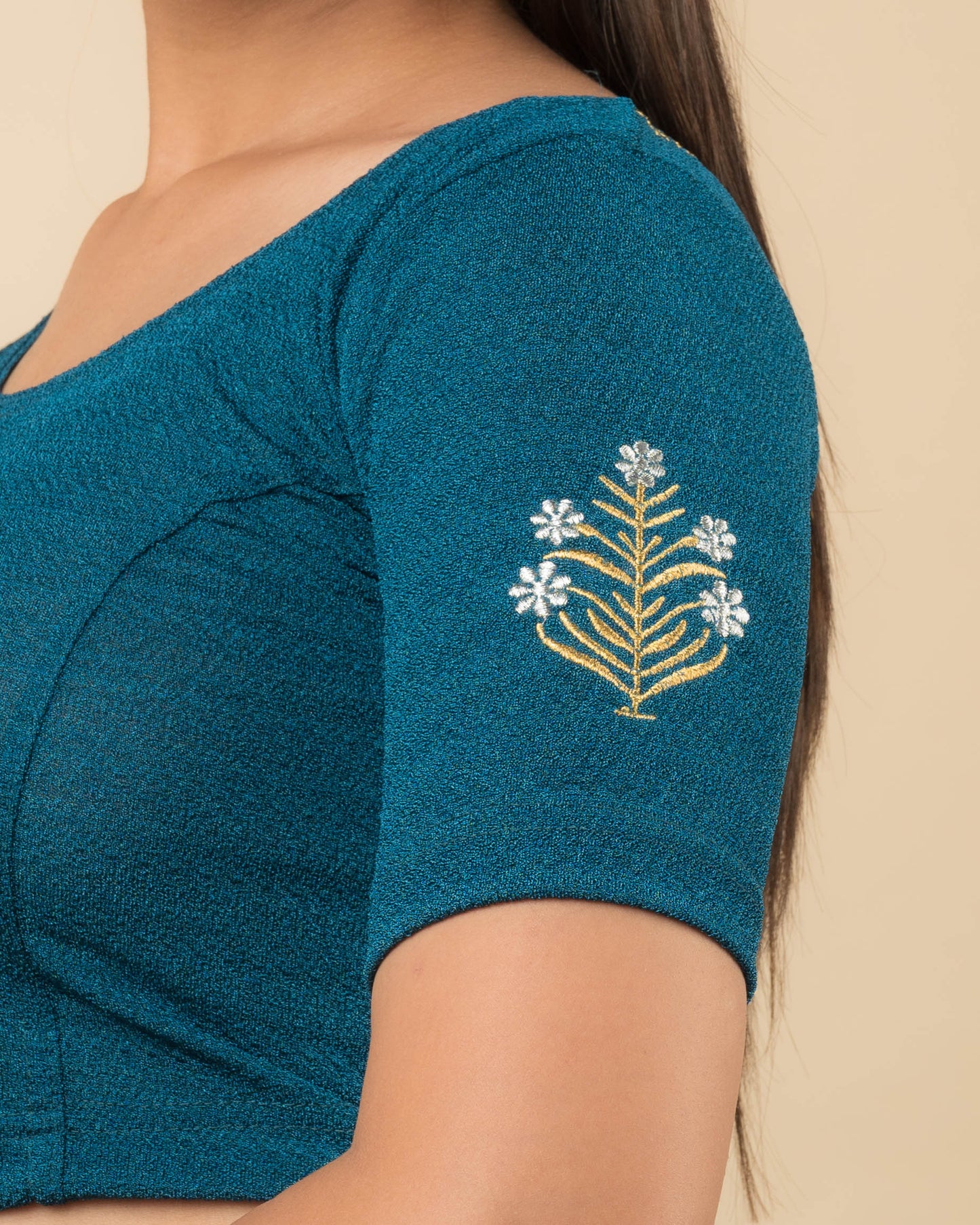 Close-up of the stretchable knit fabric detailing the buti embroidery of the readymade blouse.