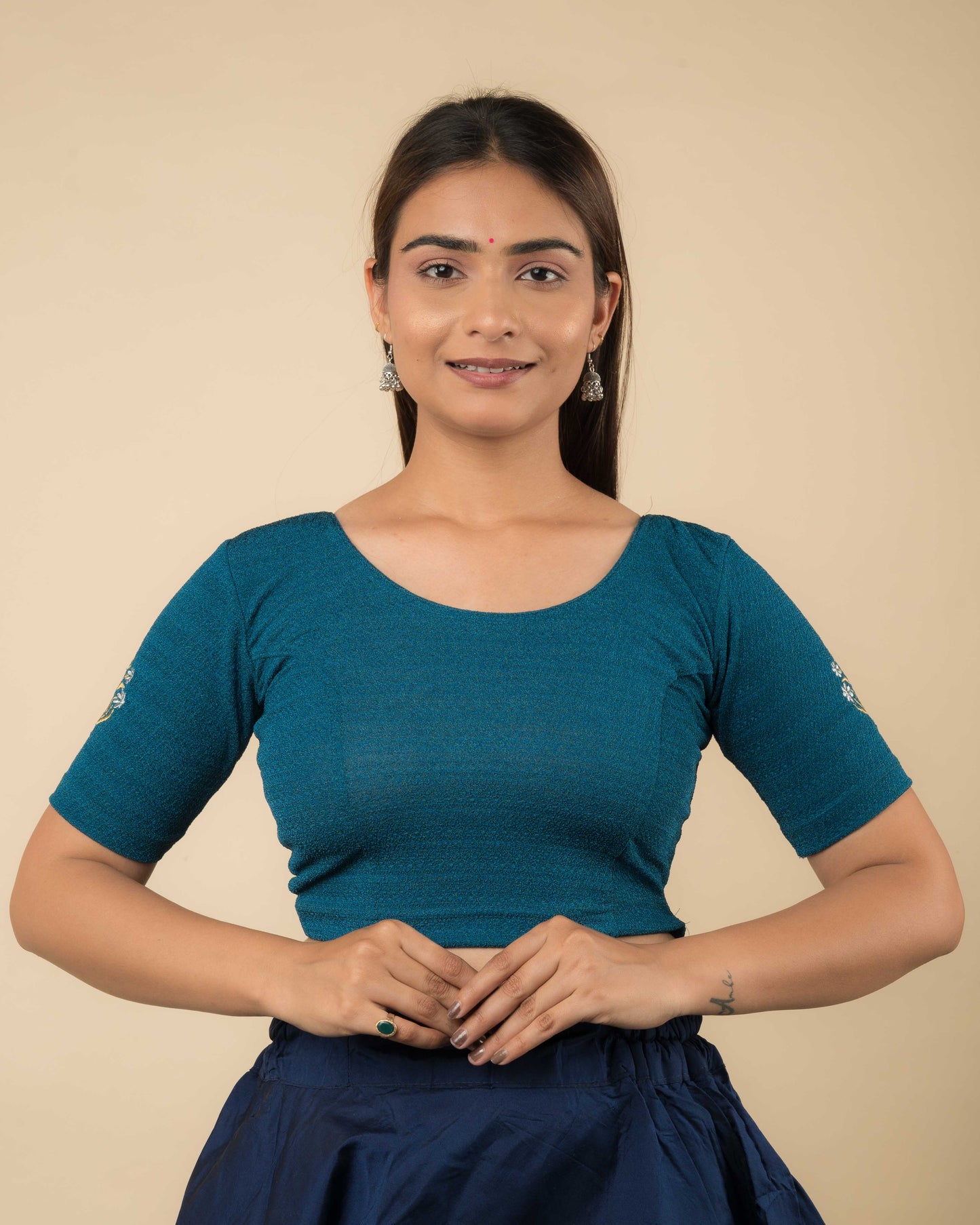 Model wearing a buti embroidered stretchable readymade blouse with elbow sleeves and round neckline.