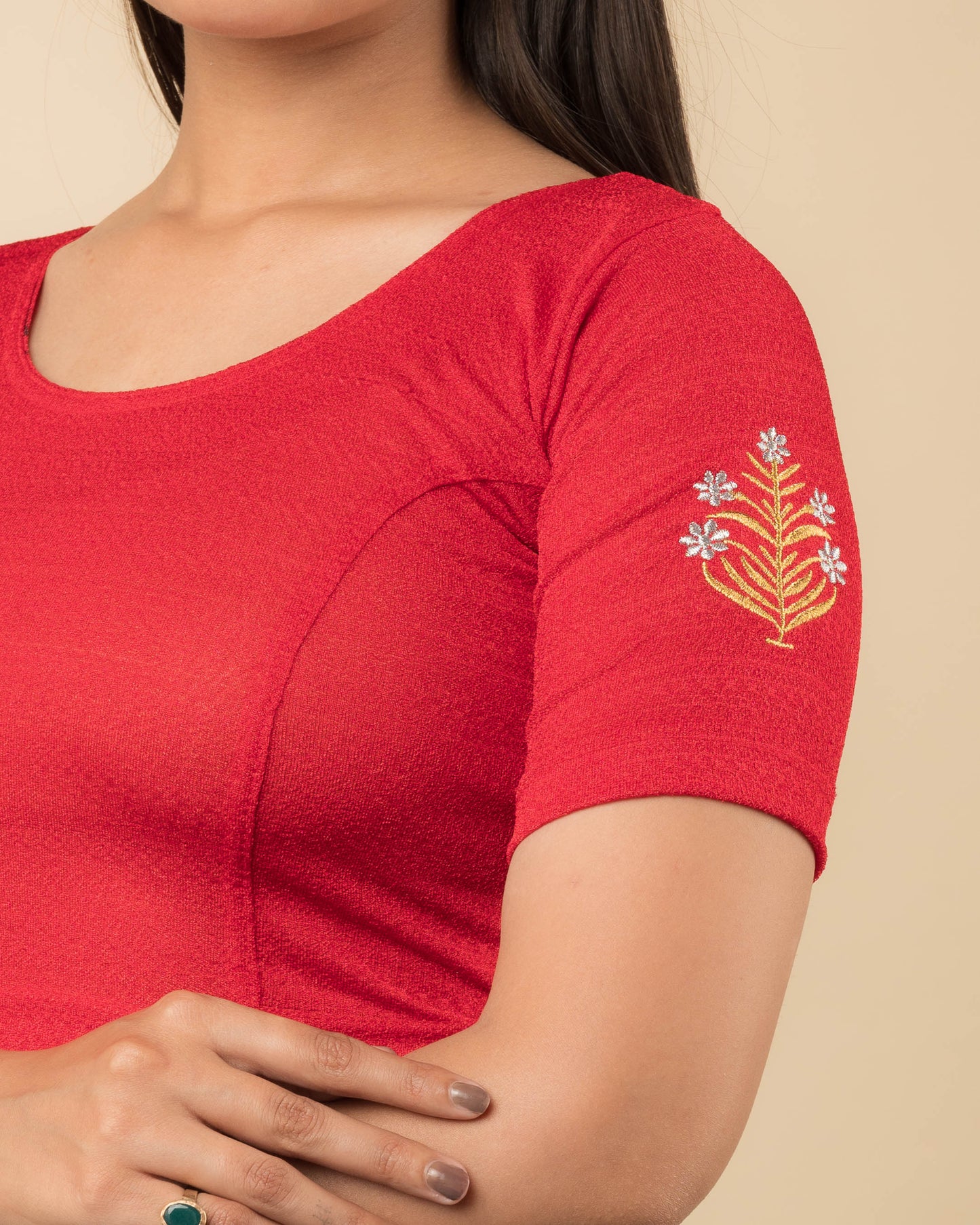 Close-up of the stretchable knit fabric detailing the buti embroidery of the readymade blouse.