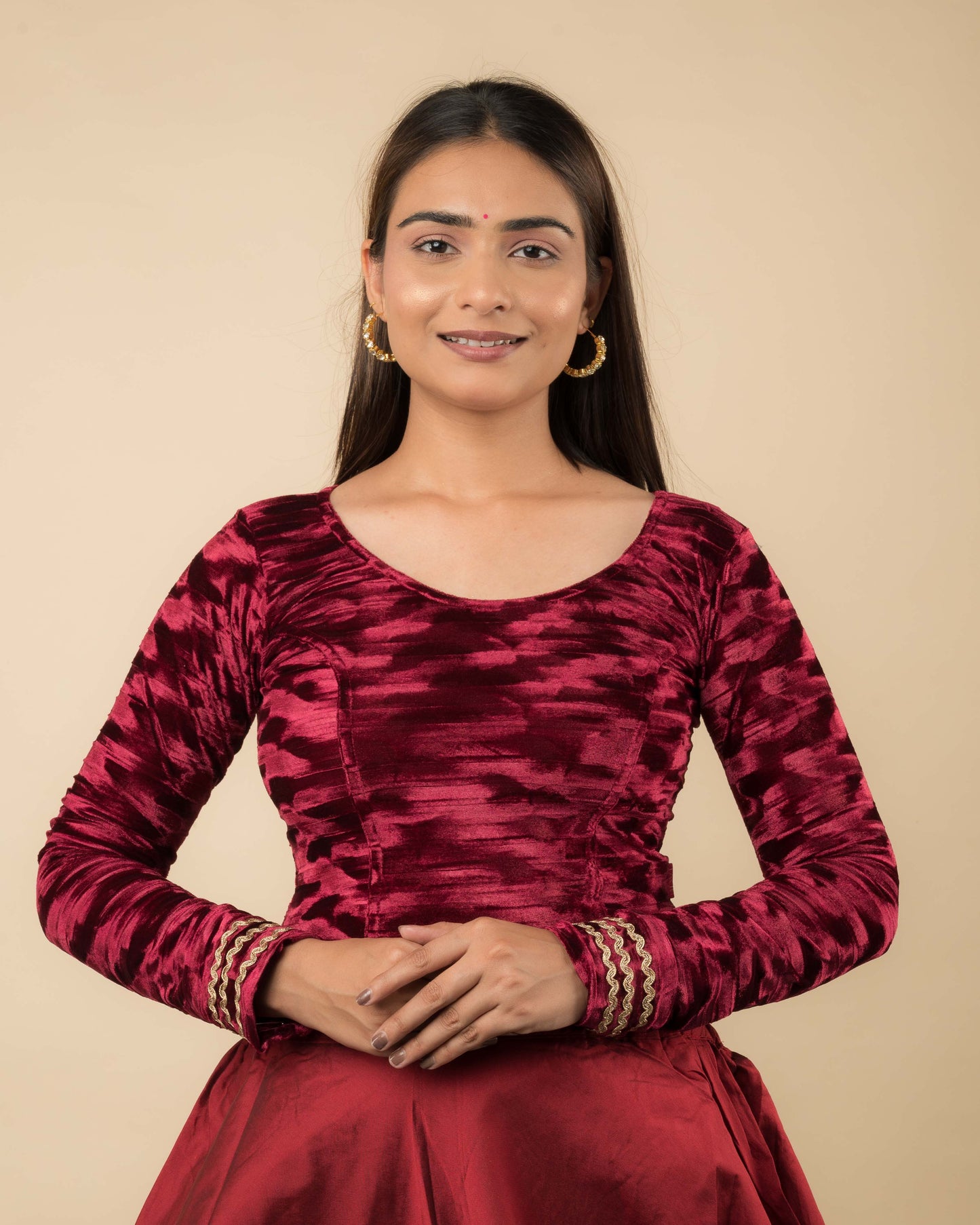 Model wearing a velvet stretchable readymade blouse with full sleeves and round neckline.