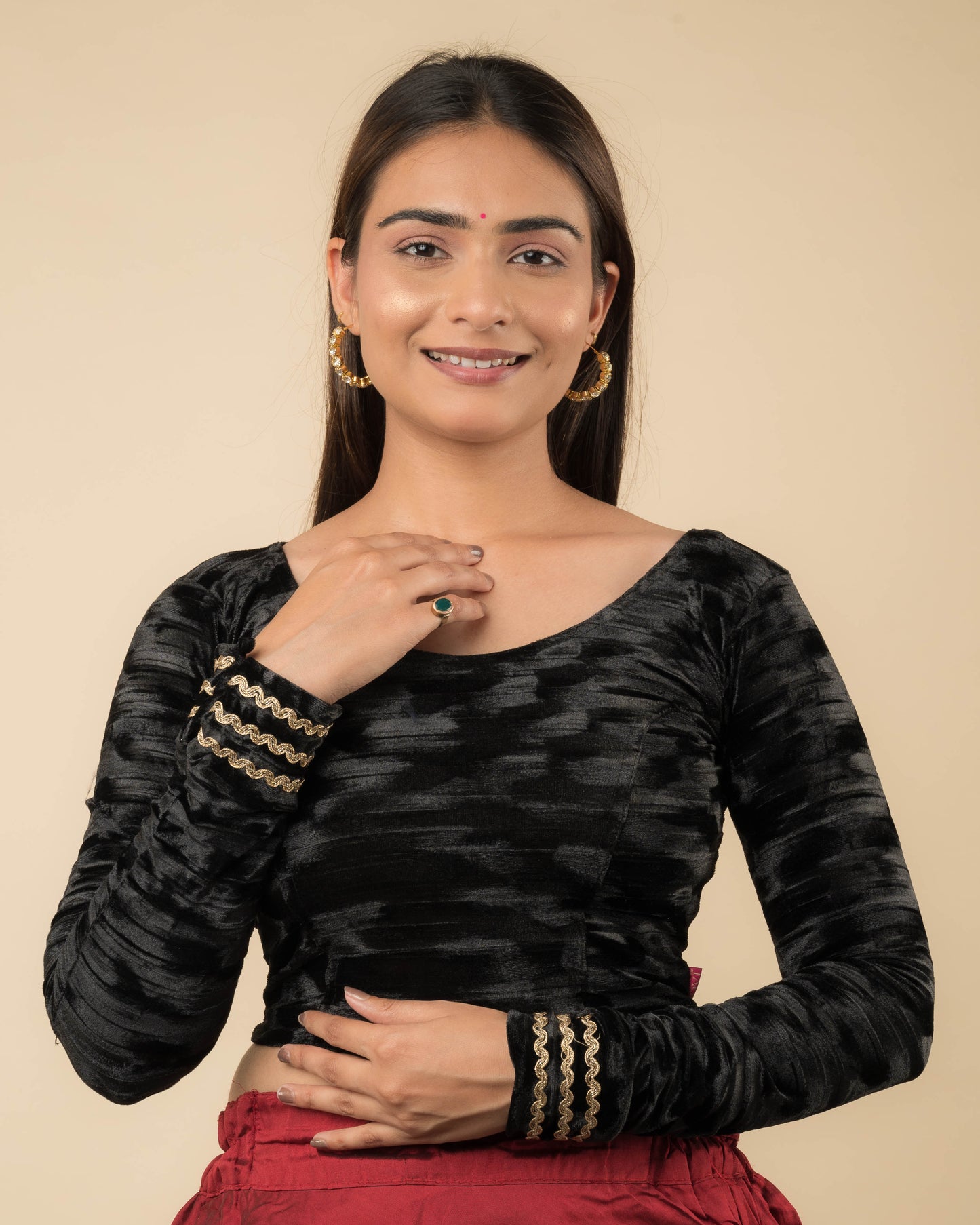 Model wearing a black velvet stretchable readymade blouse with full sleeves and round neckline.