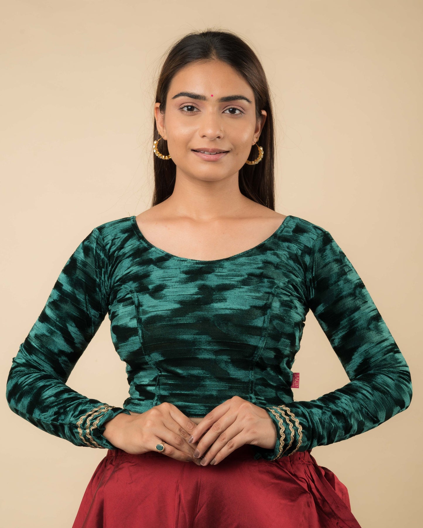 Model wearing a velvet stretchable readymade blouse with full sleeves and round neckline.