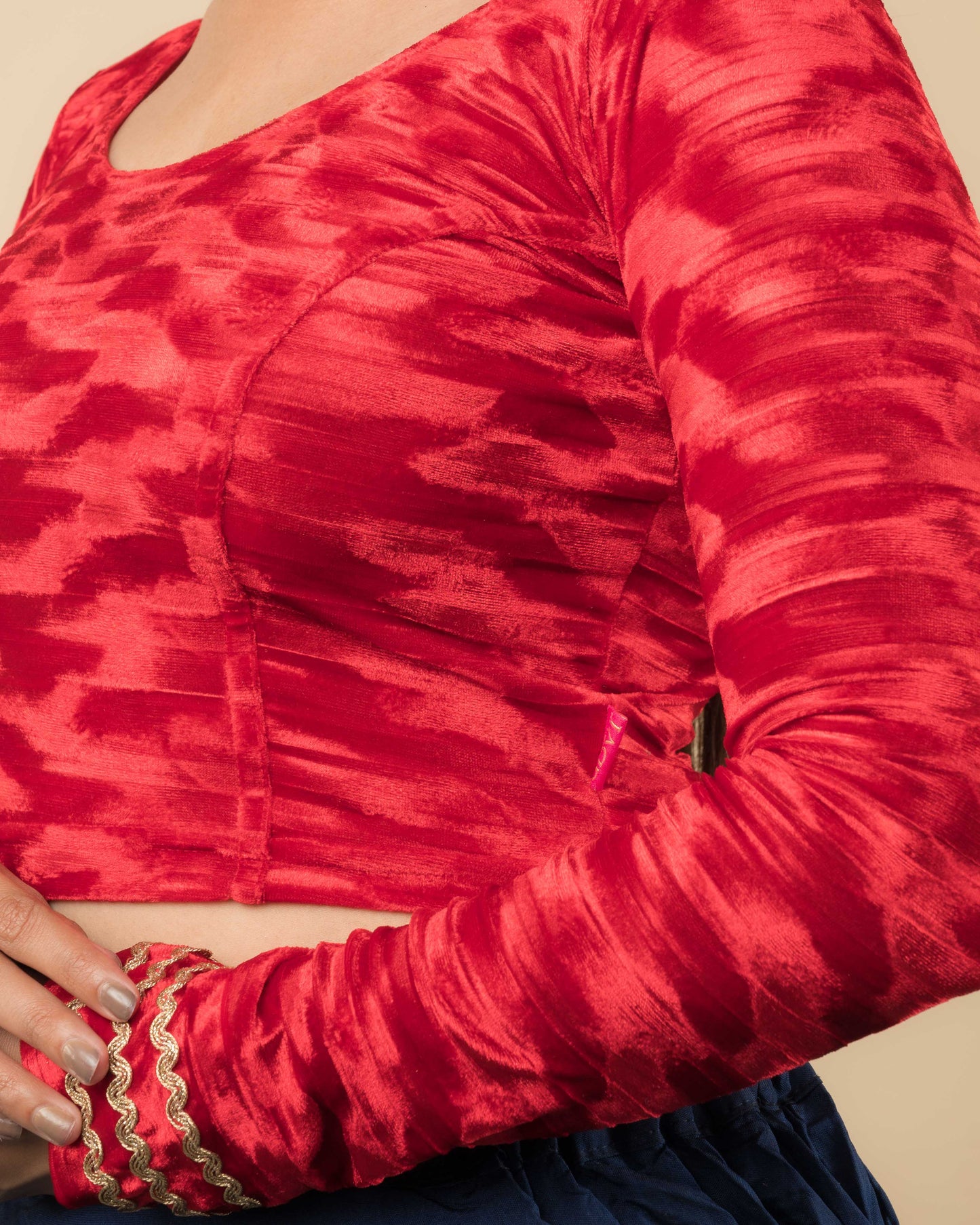 Close-up of the velvet fabric detailing the zari embroidery and stretchability of the readymade blouse.