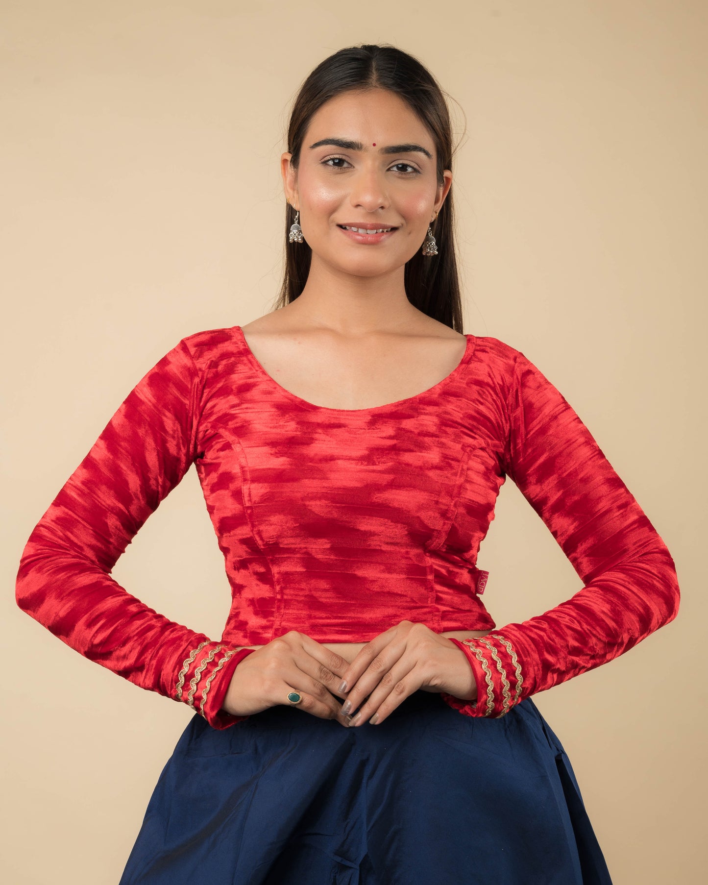 Model wearing a velvet stretchable readymade blouse with full sleeves and round neckline.