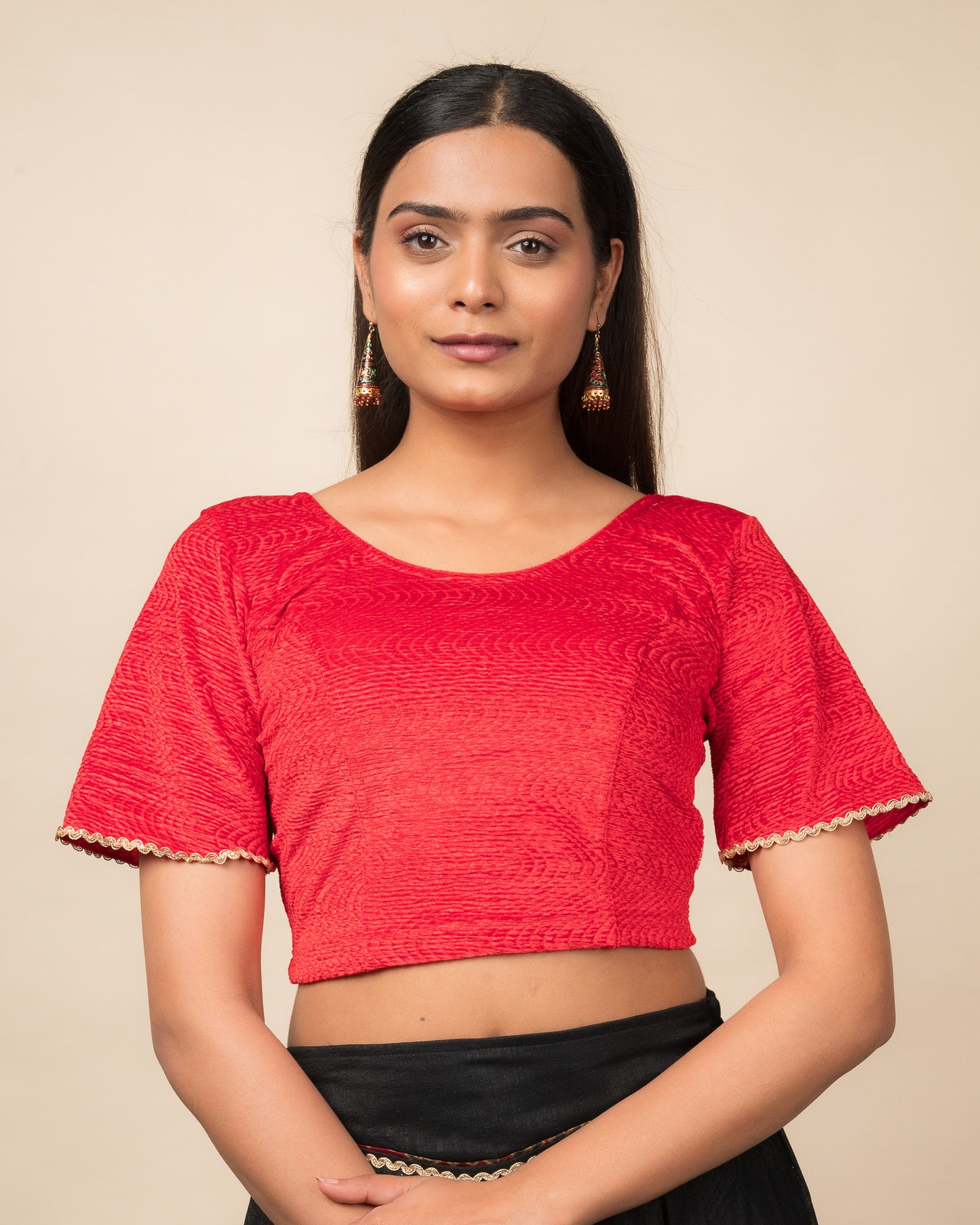 Model wearing a velvet stretchable readymade blouse with elbow-length bell sleeves and round neckline.