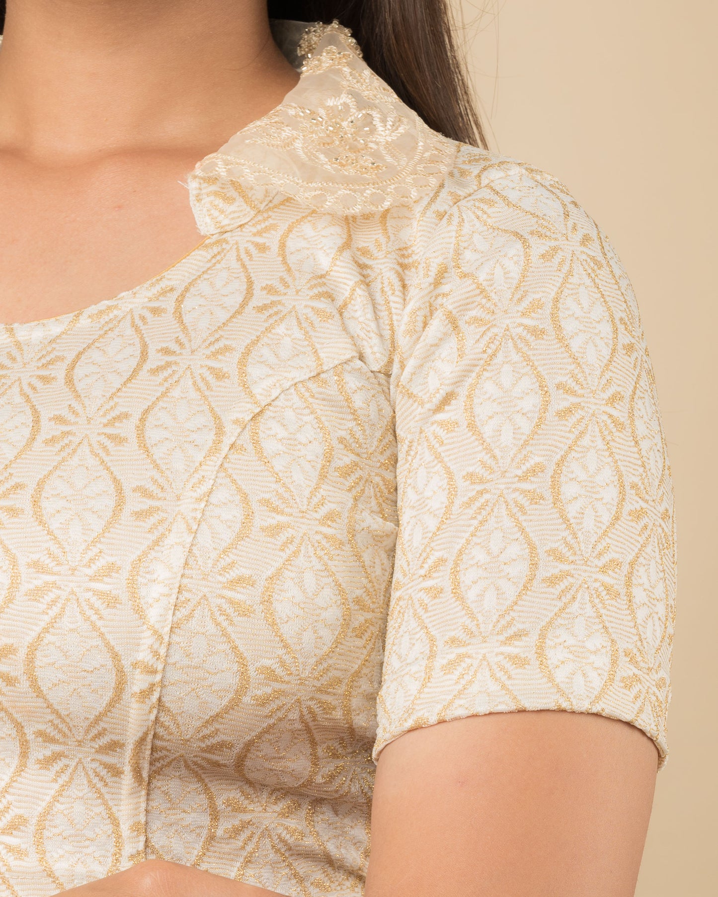 Close-up of jacquard fabric with detailed hand-beaded embroidery.