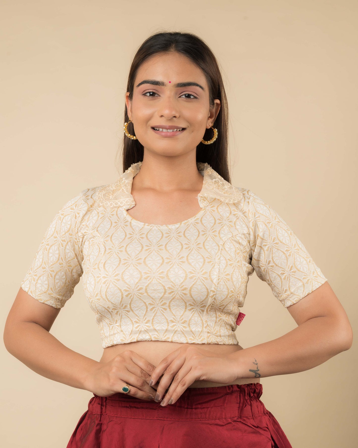 Model wearing a stretchable blouse with an embellished embroidered collar and elbow-length sleeves.