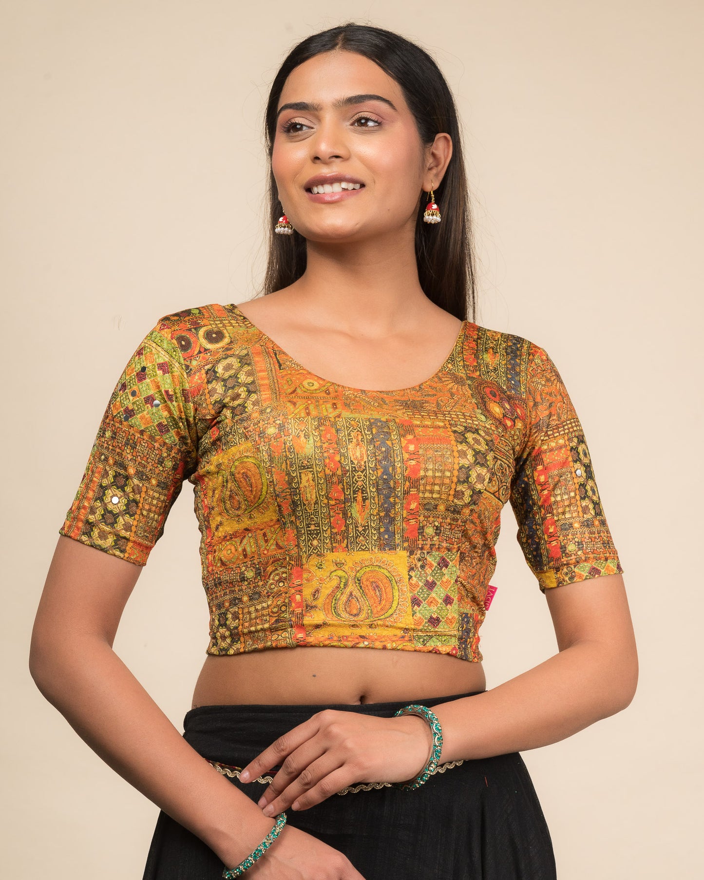 Model wearing a stretchable blouse with elbow sleeves and round neckline featuring ethnic mirror embellishments.