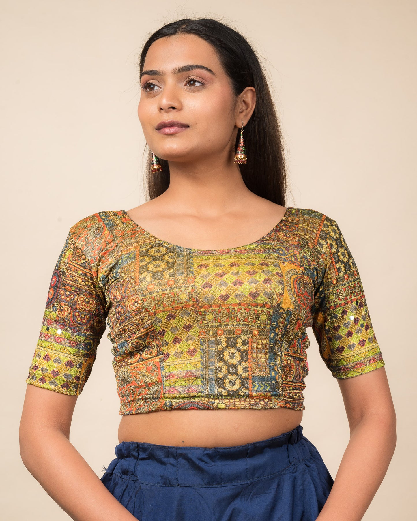 Model wearing a stretchable blouse with elbow sleeves and round neckline featuring ethnic mirror embellishments.