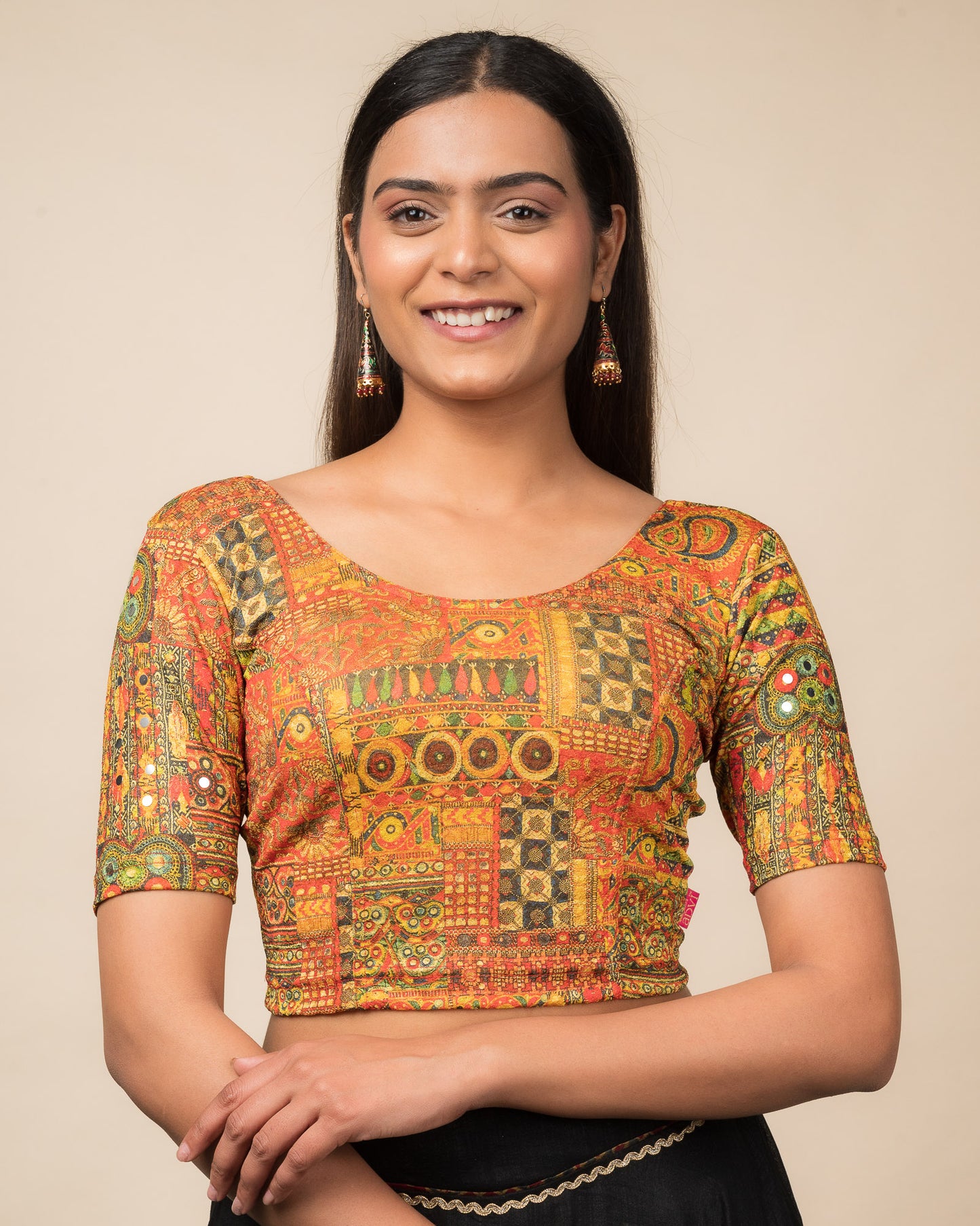 Model wearing a stretchable blouse with elbow sleeves and round neckline featuring ethnic mirror embellishments.