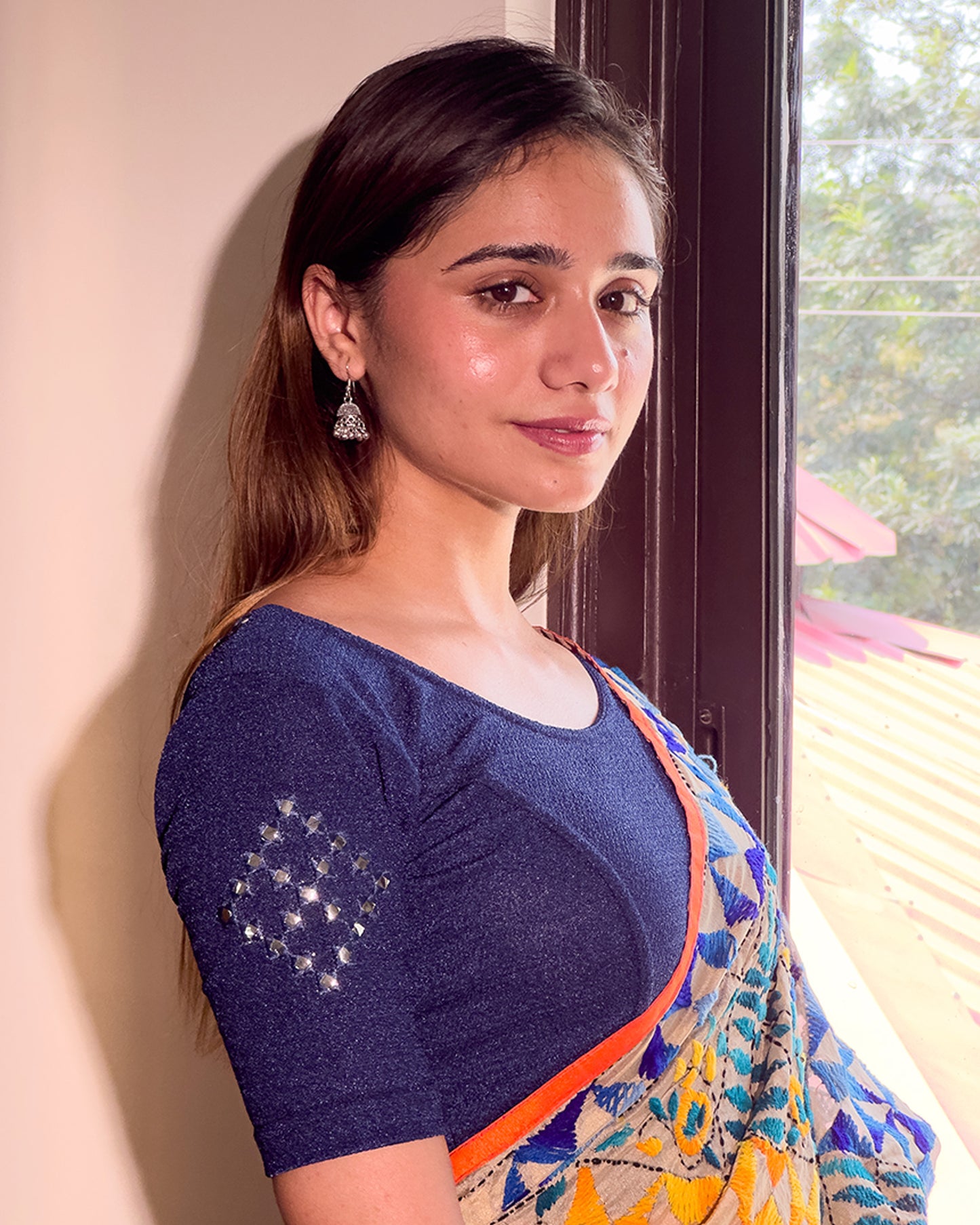 Model wearing a stretchable blouse with elbow-length sleeves and round neckline featuring mirror-embroidered butis.