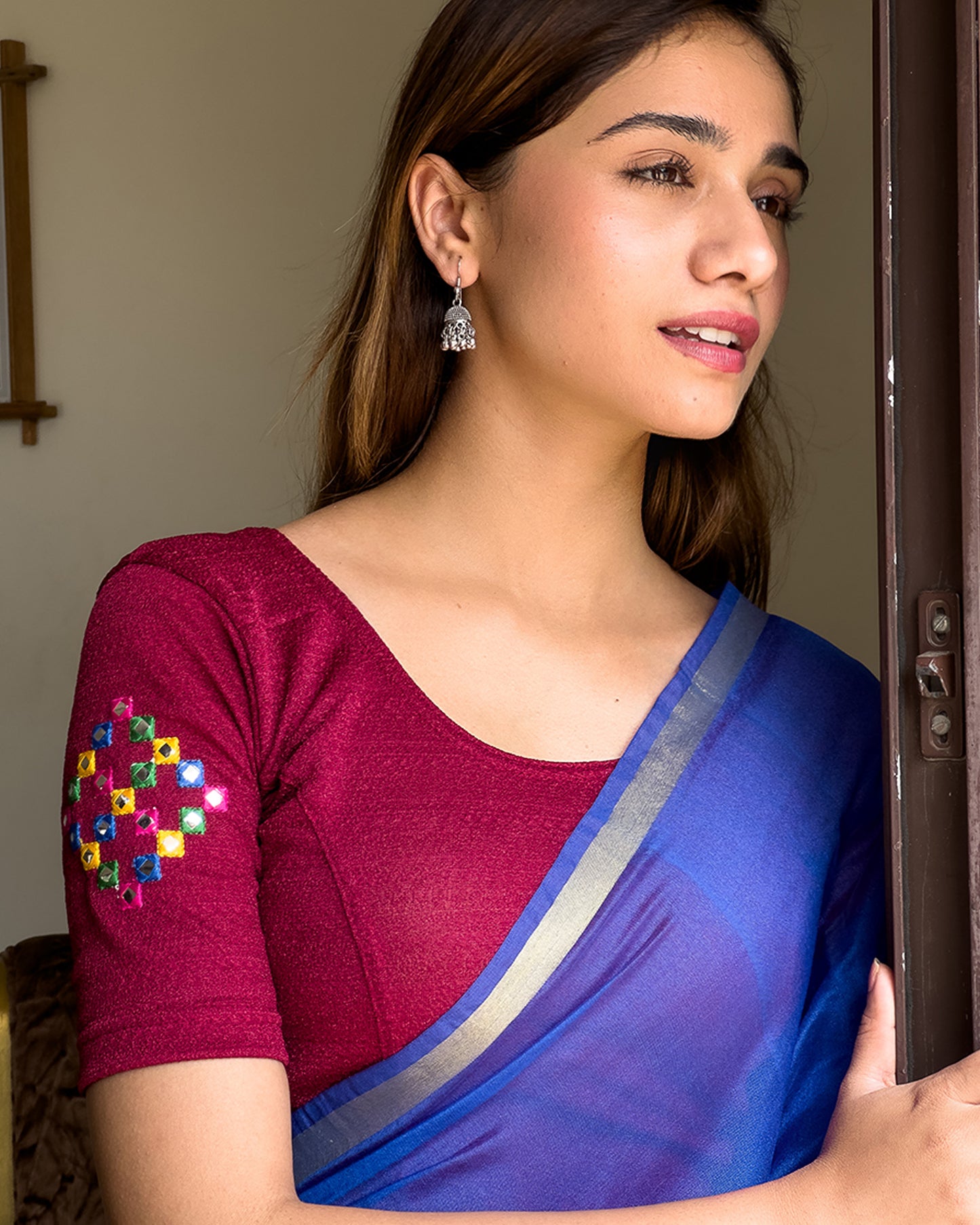 Model wearing a stretchable blouse with mirror embroidery on the neckline and sleeves.