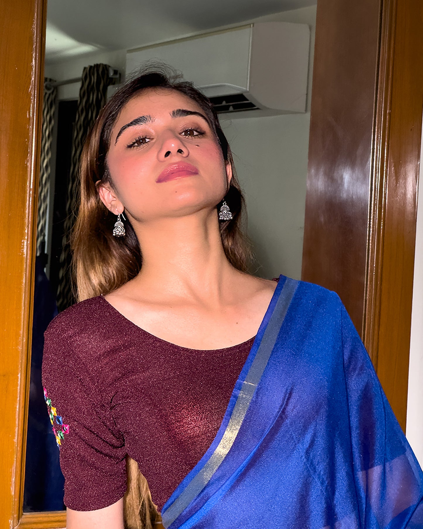 Model wearing a stretchable blouse with mirror embroidery on the neckline and sleeves.