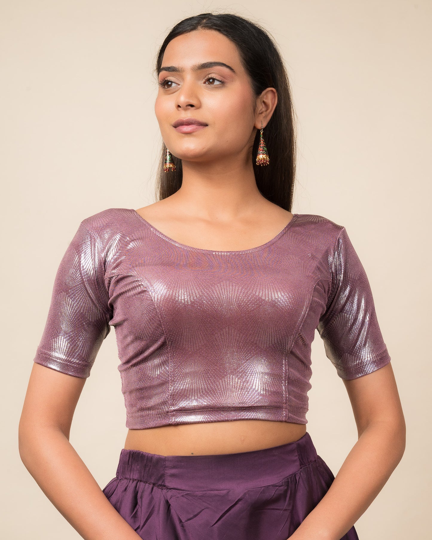 Model wearing a stretchable slip-on blouse with round neckline and elbow sleeves, showcasing a sleek metallic finish.