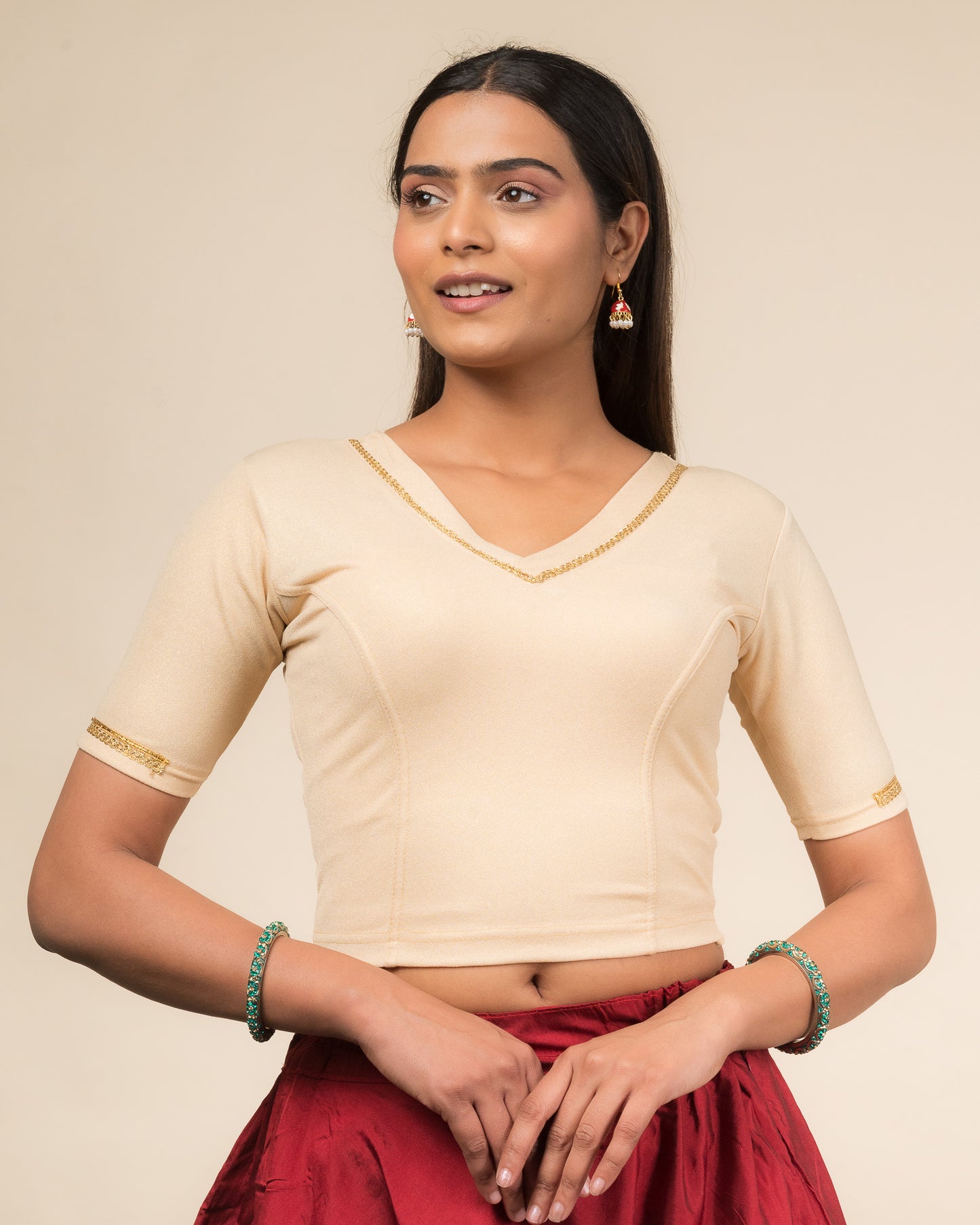 Model wearing a stretchable blouse with elbow sleeves and a V-neckline featuring metallic sheen.
