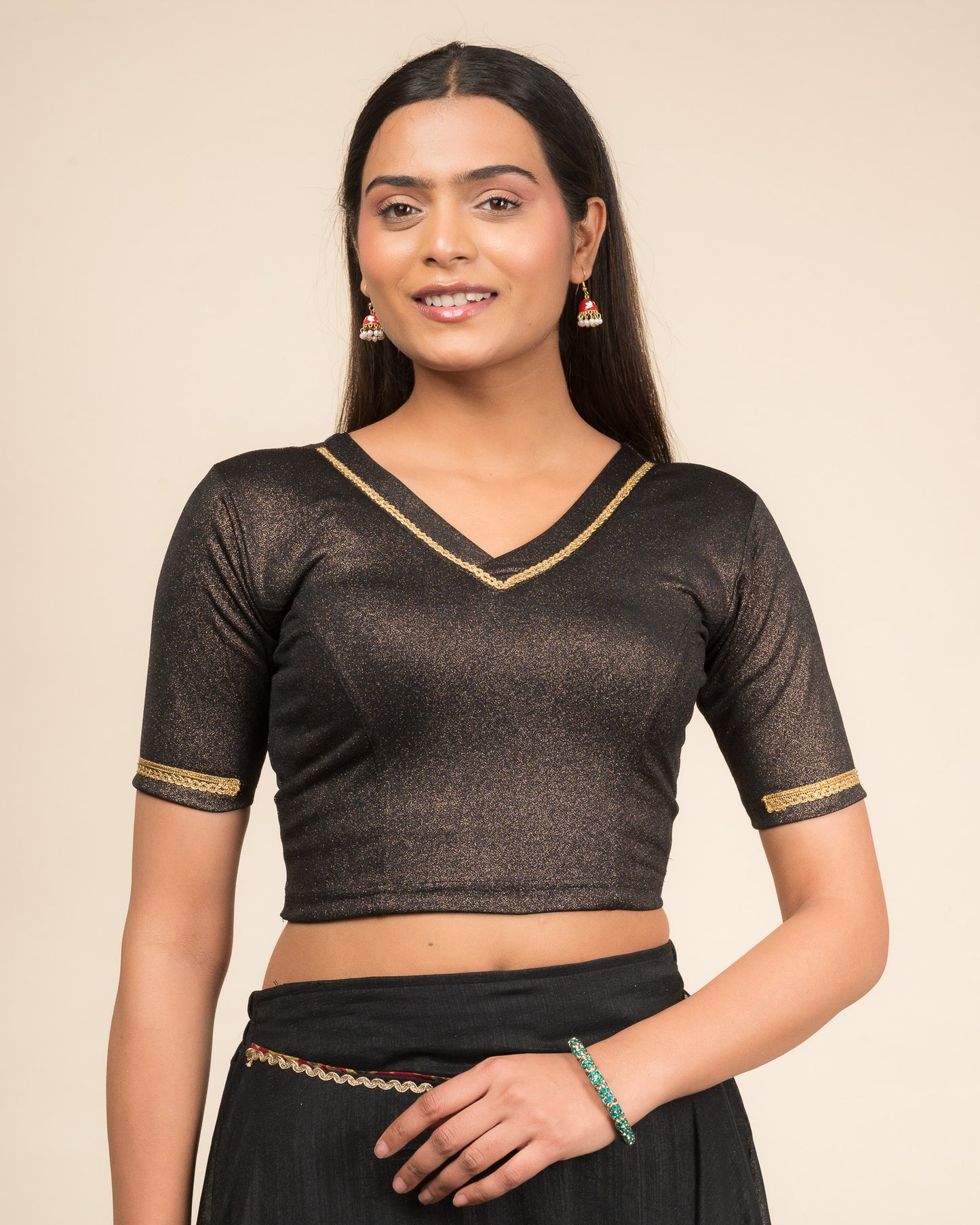 Model wearing a stretchable blouse with elbow sleeves and a V-neckline featuring metallic sheen.