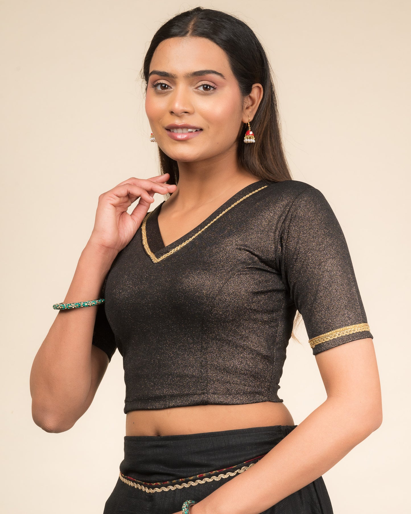 Model wearing a stretchable blouse with elbow sleeves and a V-neckline featuring metallic sheen.