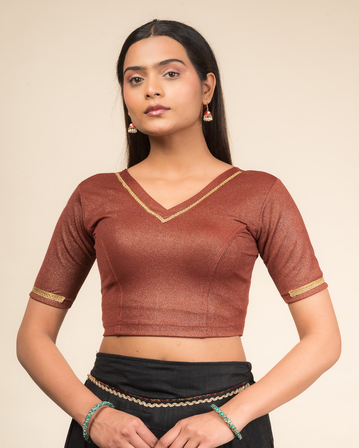 Model wearing a stretchable blouse with elbow sleeves and a V-neckline featuring metallic sheen.