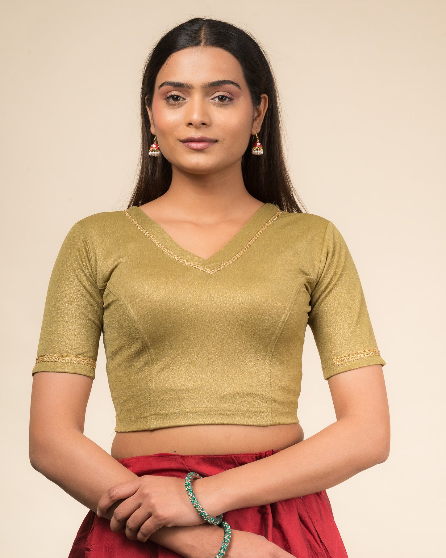 Model wearing a stretchable blouse with elbow sleeves and a V-neckline featuring metallic sheen.