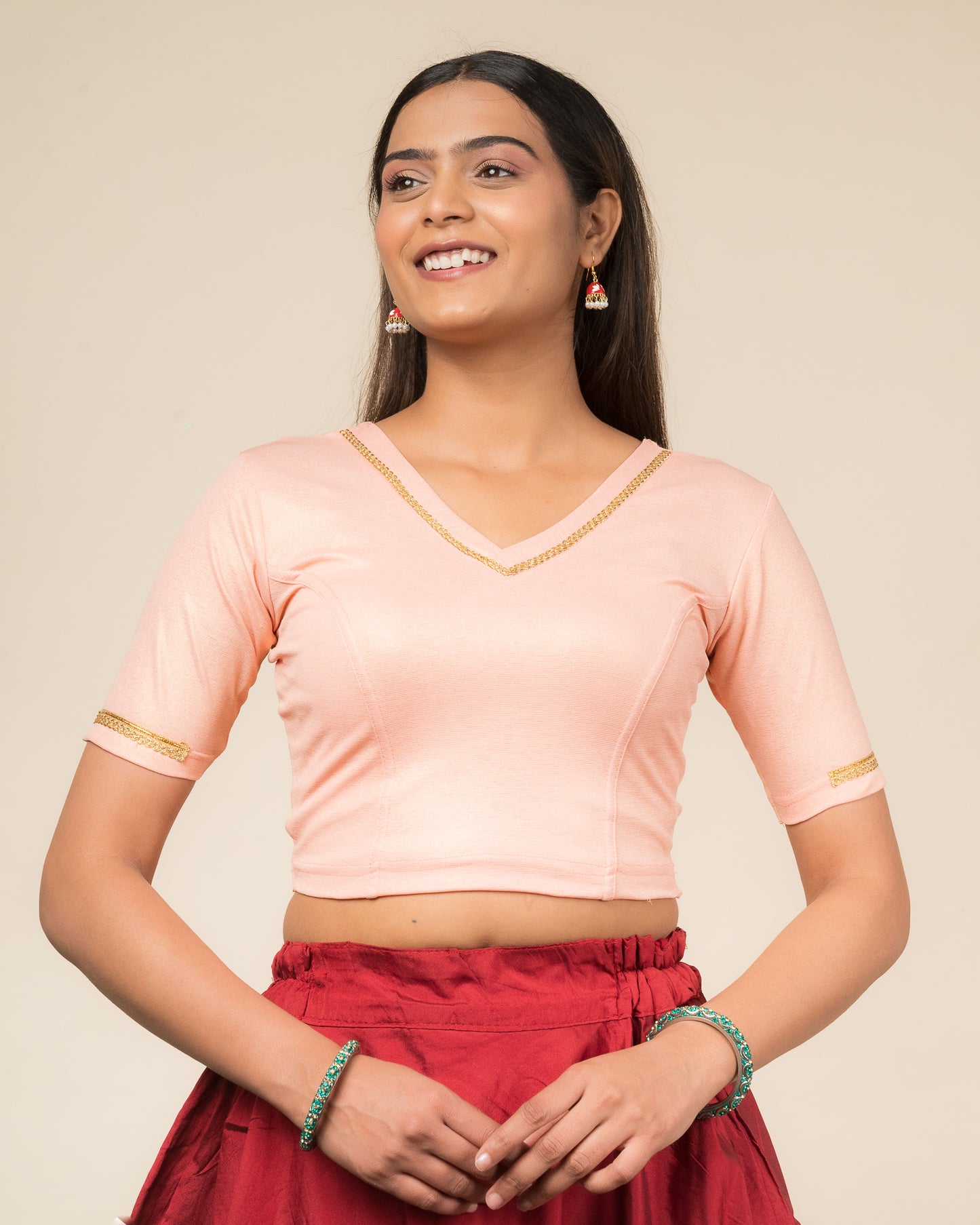 Model wearing a stretchable blouse with elbow sleeves and a V-neckline featuring metallic sheen.