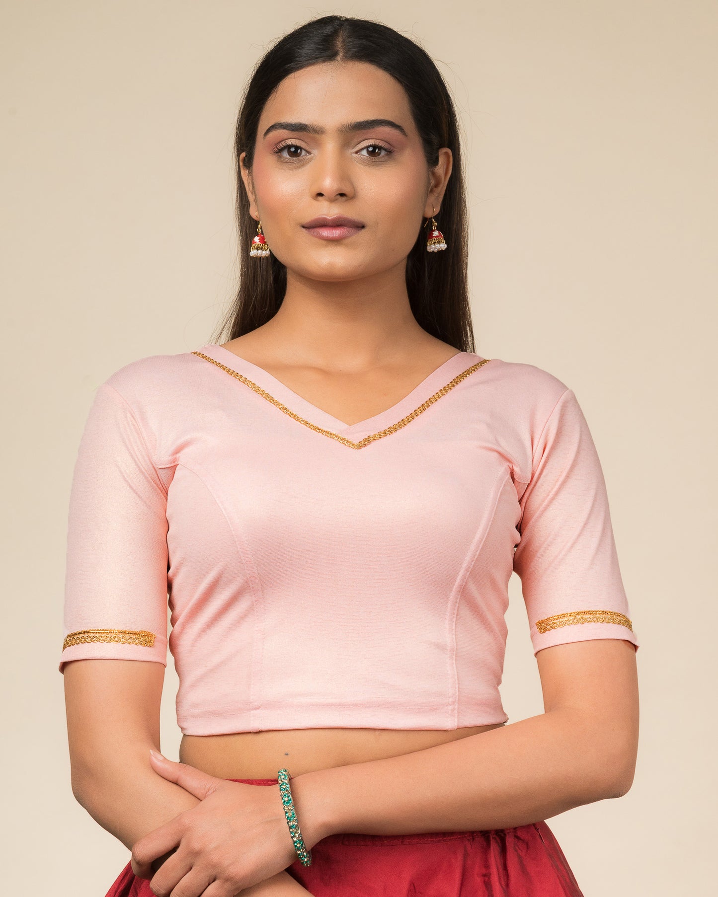 Model wearing a stretchable blouse with elbow sleeves and a V-neckline featuring metallic sheen.