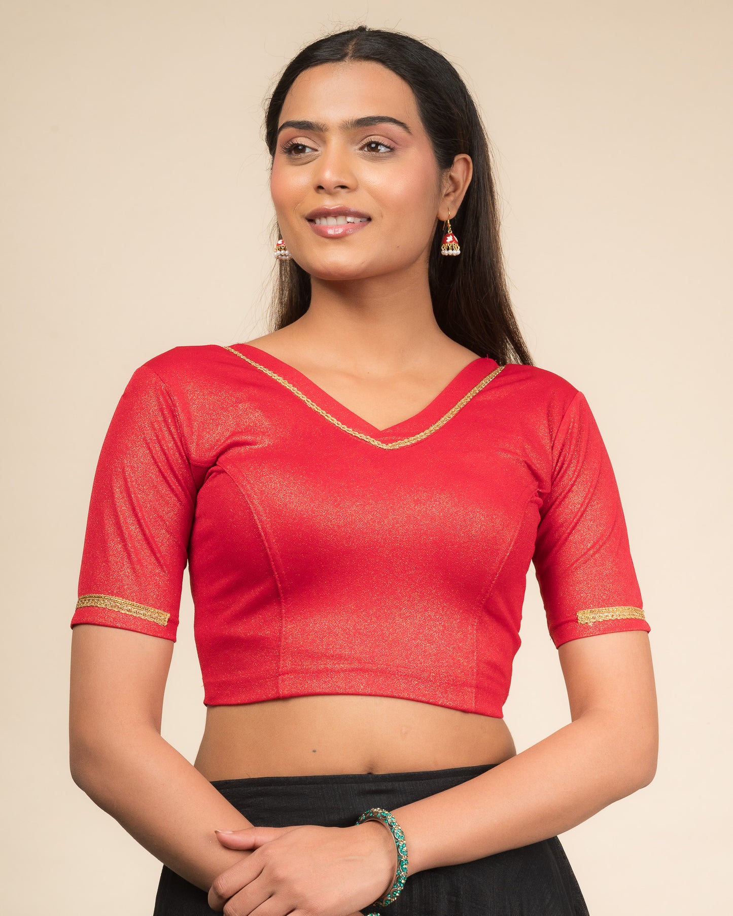 Model wearing a stretchable blouse with elbow sleeves and a V-neckline featuring metallic sheen.